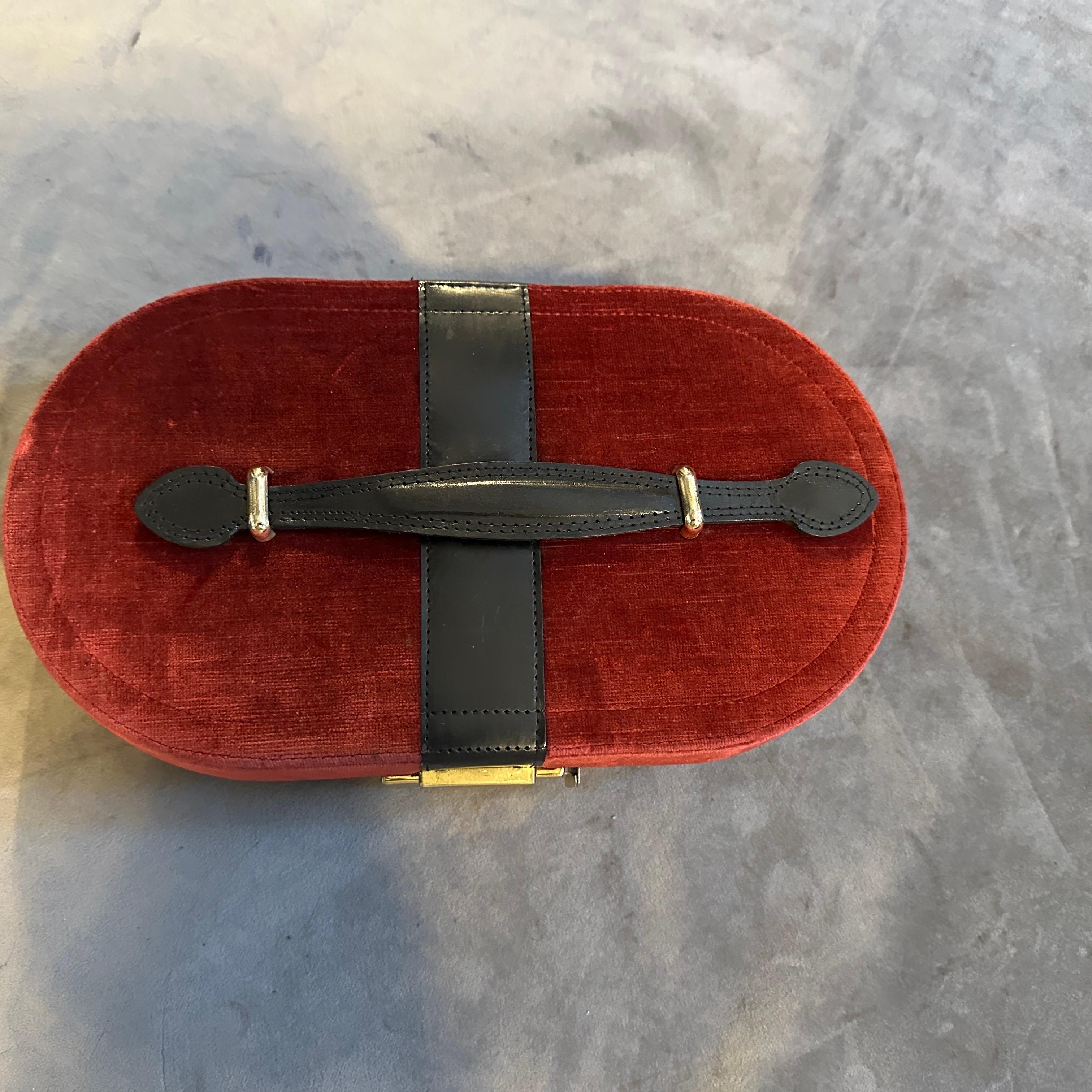 Transpórtate a la elegancia de la Italia de los años 70 con este exquisito joyero de viaje. Envuelta en rico terciopelo rojo con detalles de cuero negro en contraste, esta pieza evoca el glamour intemporal de una época pasada. La silueta ovalada y