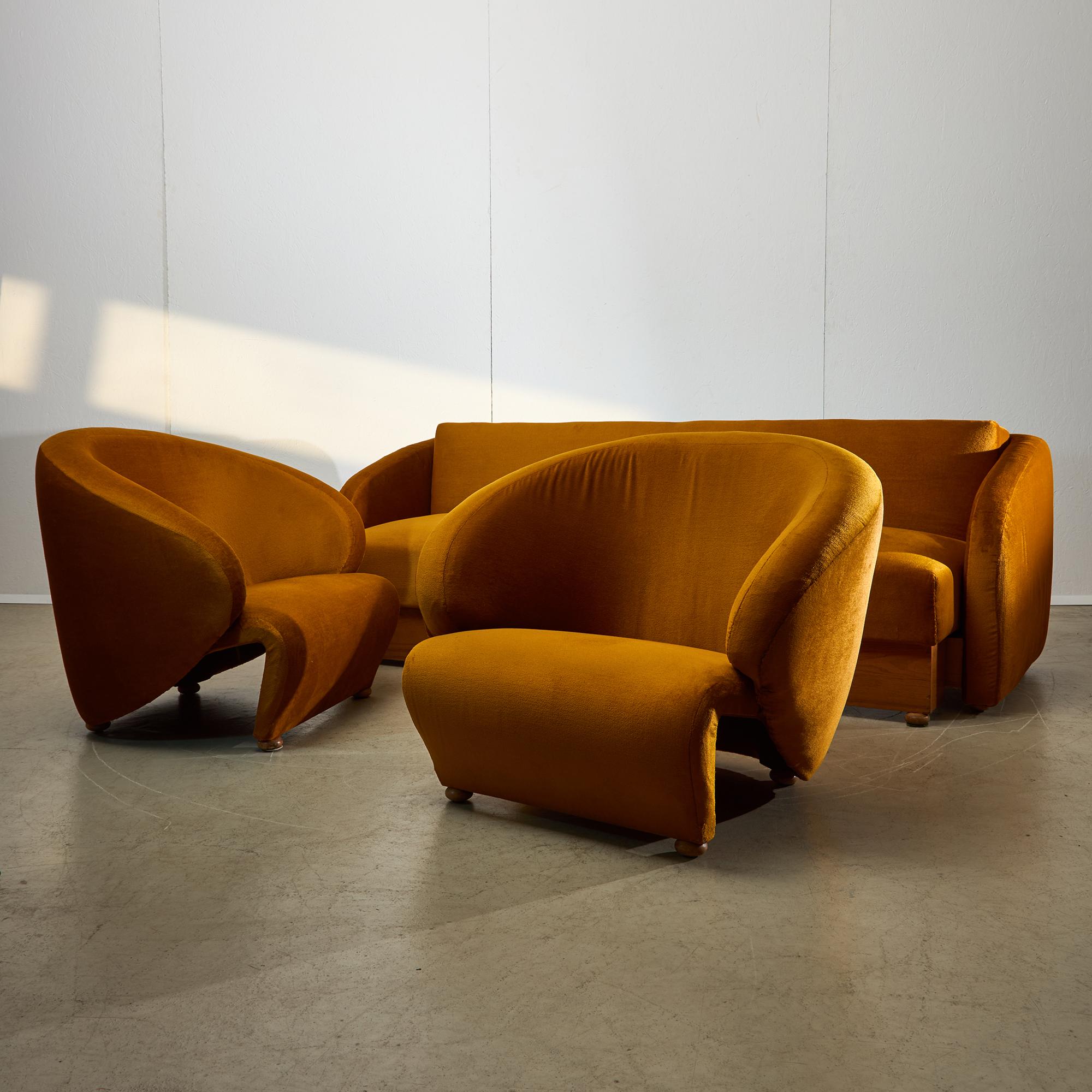 Presentamos un excepcional conjunto de sofás de los años 70 de Sandor Bedecs, una representación por excelencia del diseño de mediados de siglo que combina ingeniosamente comodidad y elegancia. Cubierto de lujoso terciopelo, el sofá y sus dos