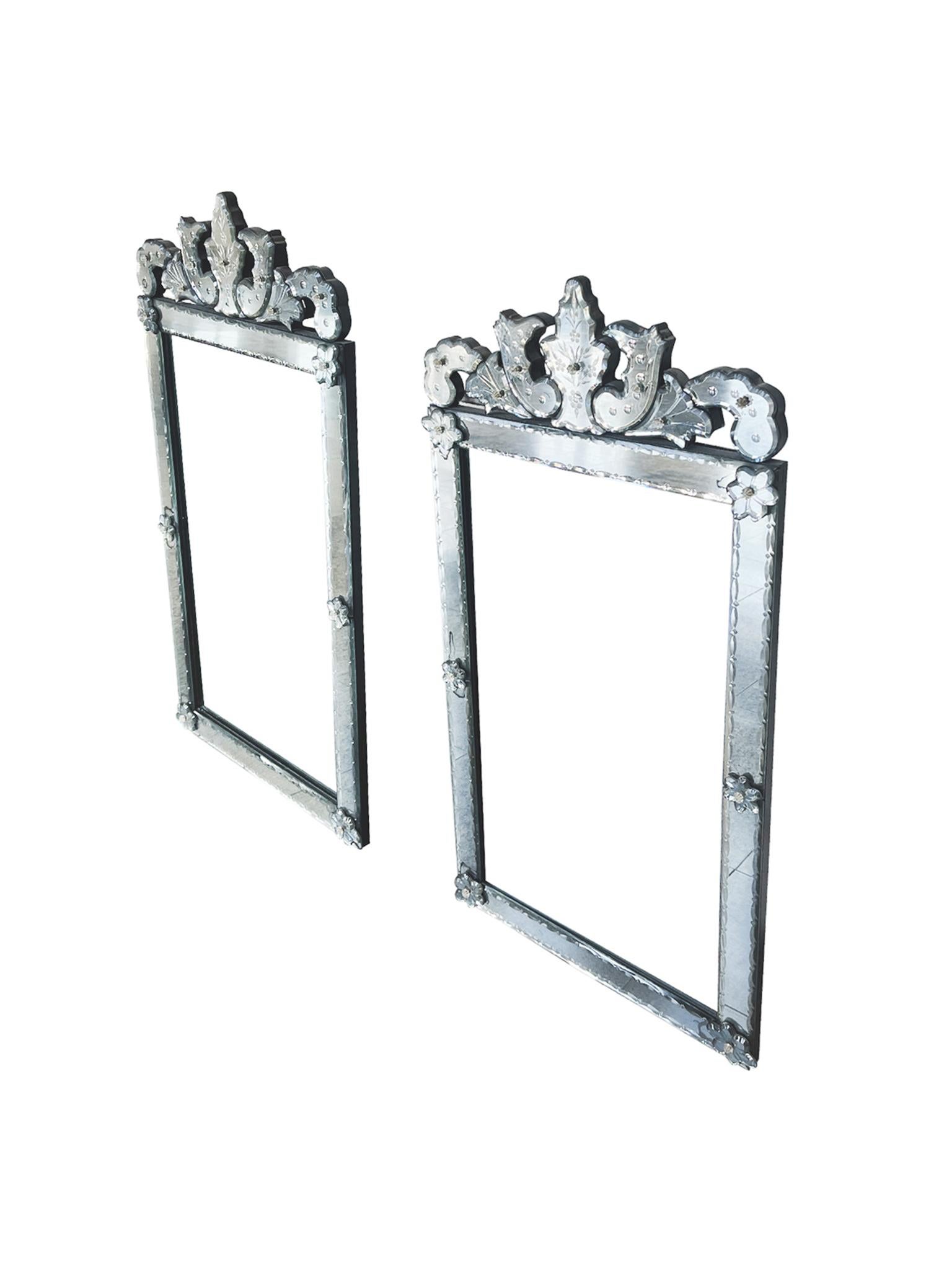 These wall mirrors were made in the 1970s in the ornate Venetian style. It features ornamental flourishes at the top, beveled edges, etched floral surface patterns, and floral medallions with the characteristic hint of gold. The backs of the mirrors