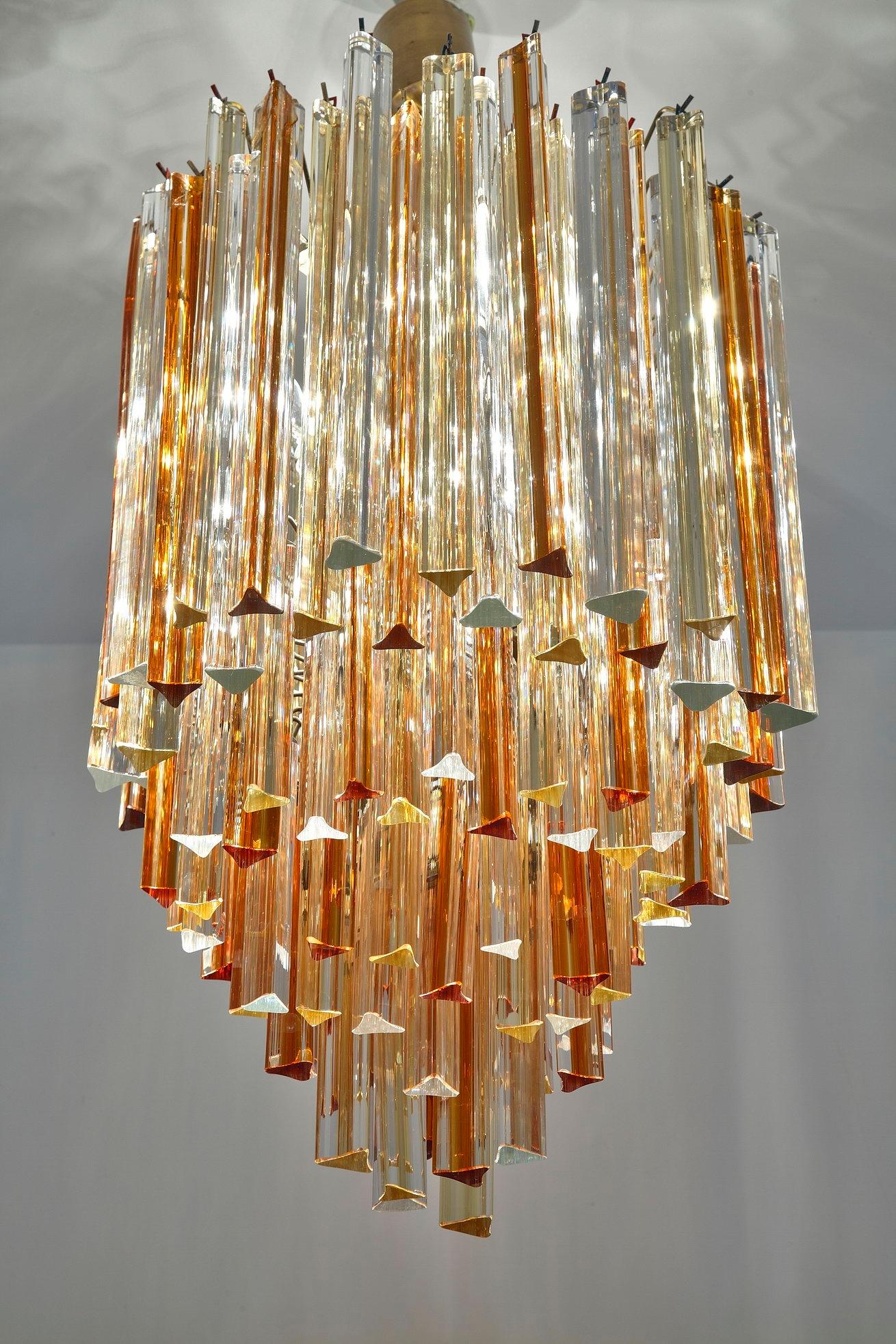 1970s Italian Venini Murano Triedri cascade chandelier. It is decorated with long amber and clear crystal pendants on a gilt metal structure.

H. 70cm without the chain.

circa 1970
Dimensions: W 17.7 in, D 17.7in, H 35.4in.
Dimensions: L