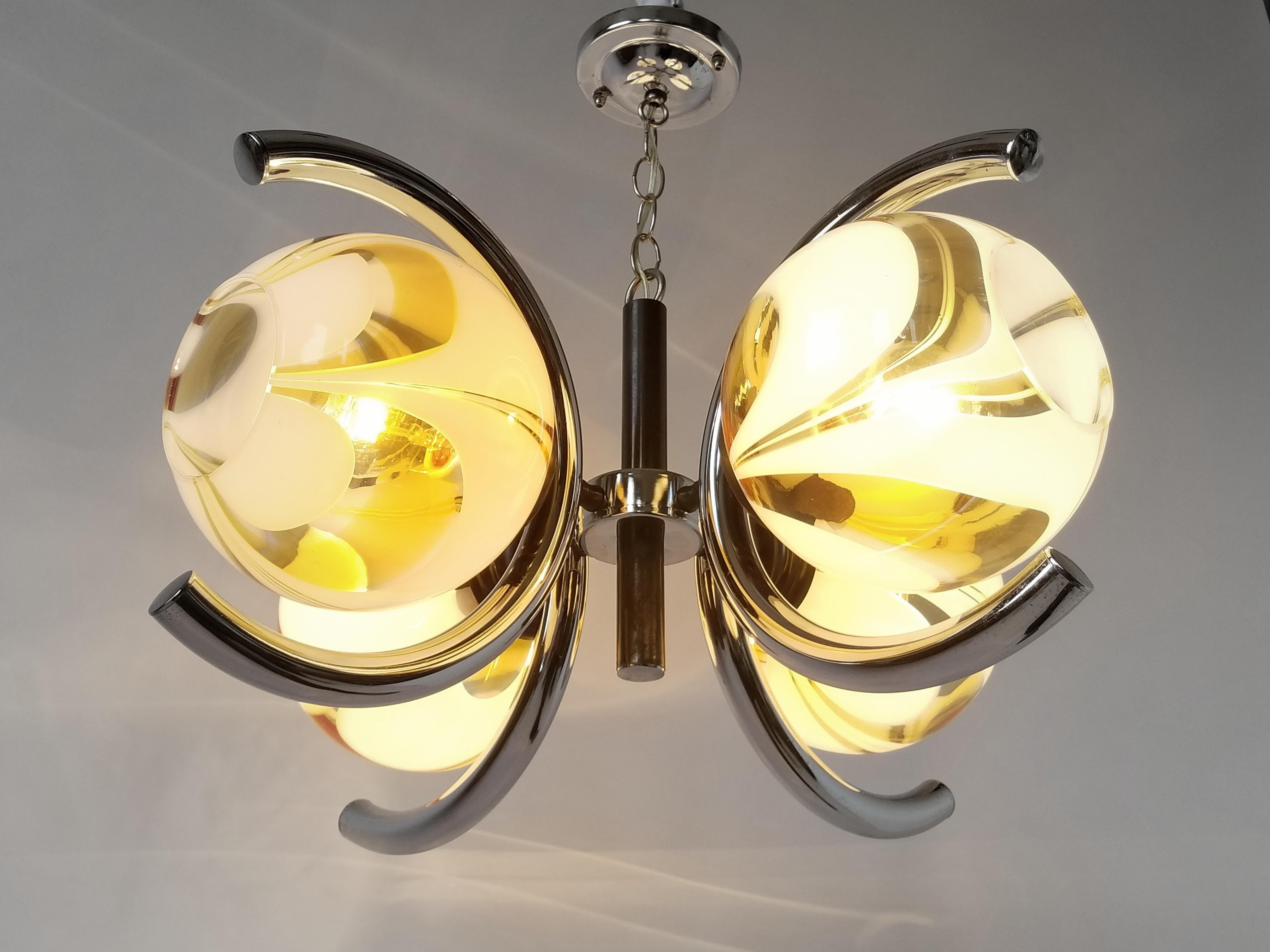 Superb mouth blowed glass shade in the style of Venini sitting on a chrome base. 

Glass shade measure 8 in. diameter. 

Four regular E26 size socket rated at 60 watt each. 

Measure: 23 in. wide by 12 in. high, chain length to your