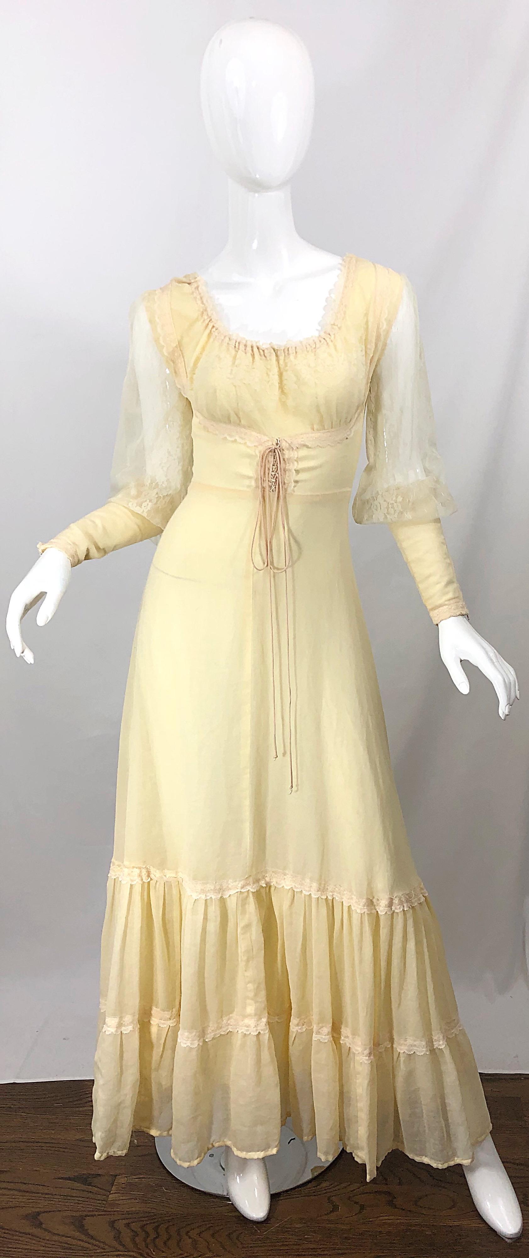 Beautiful 70s Victorian inspired pale yellow cotton voile and lace maxi dress! Features laces up the front. Semi sheer lace sleeves with fitted cotton cuffs that have zippers on each. Hidden metal zipper up the back with hook-and-eye closure. In