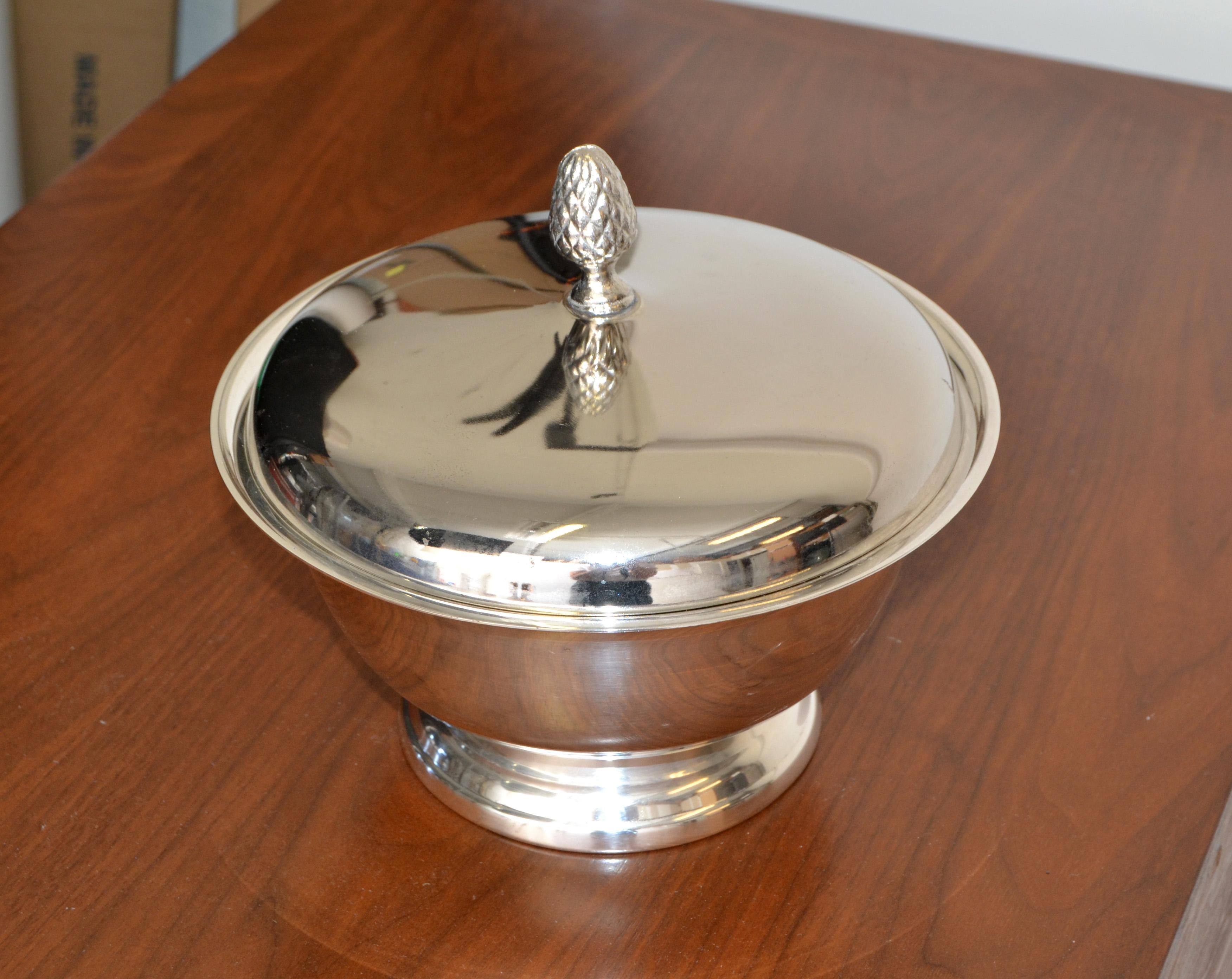 1970th Towle Silversmiths Company produced footed and lidded bowl,designed in the style by Paul Revere.
This is the 8 inches diameter bow with pinecone shaped finial.
Stamped at the base Towle Silver plated with trademark.
In vintage condition