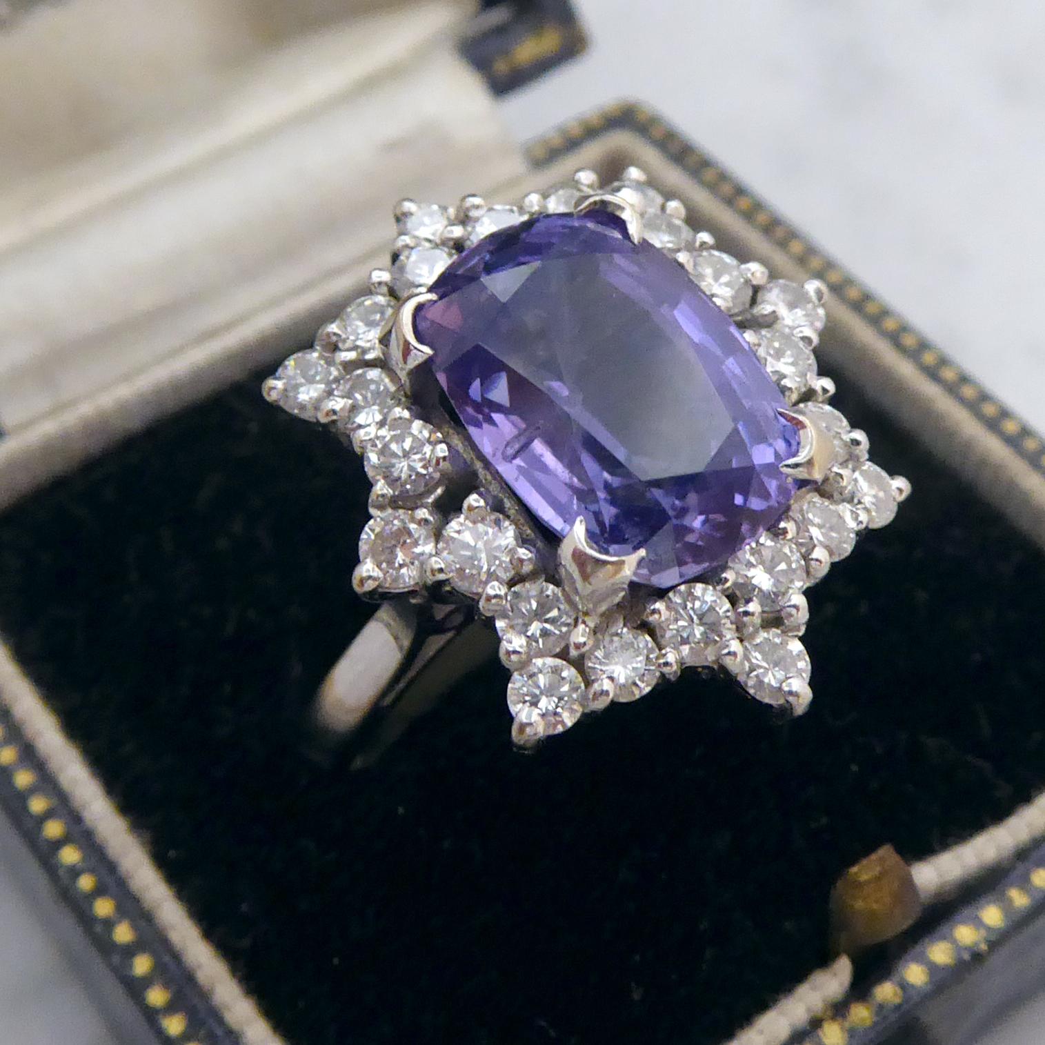 A vintage sapphire and diamond cluster style ring, set to the centre with a 5.0 carat, oval, mixed cut, purple sapphire measuring 11.71mm x 8.21mm x 5.99mm deep, claw set in white gold to the centre of an eight-pointed star surround of 24 round