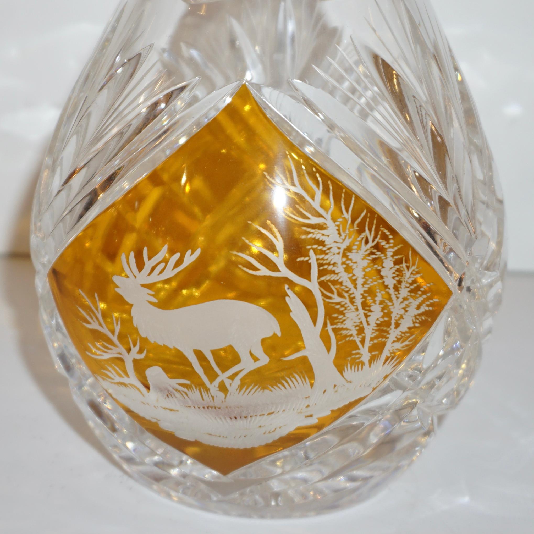 1970s Bohemian overlaid blown glass whiskey/liqueur bottle with stopper, all hand cut with gothic design decorated with an engraved elk, very high-quality diamond-cuts all around, also on the base. The amber color is pure gold in the glass.
 