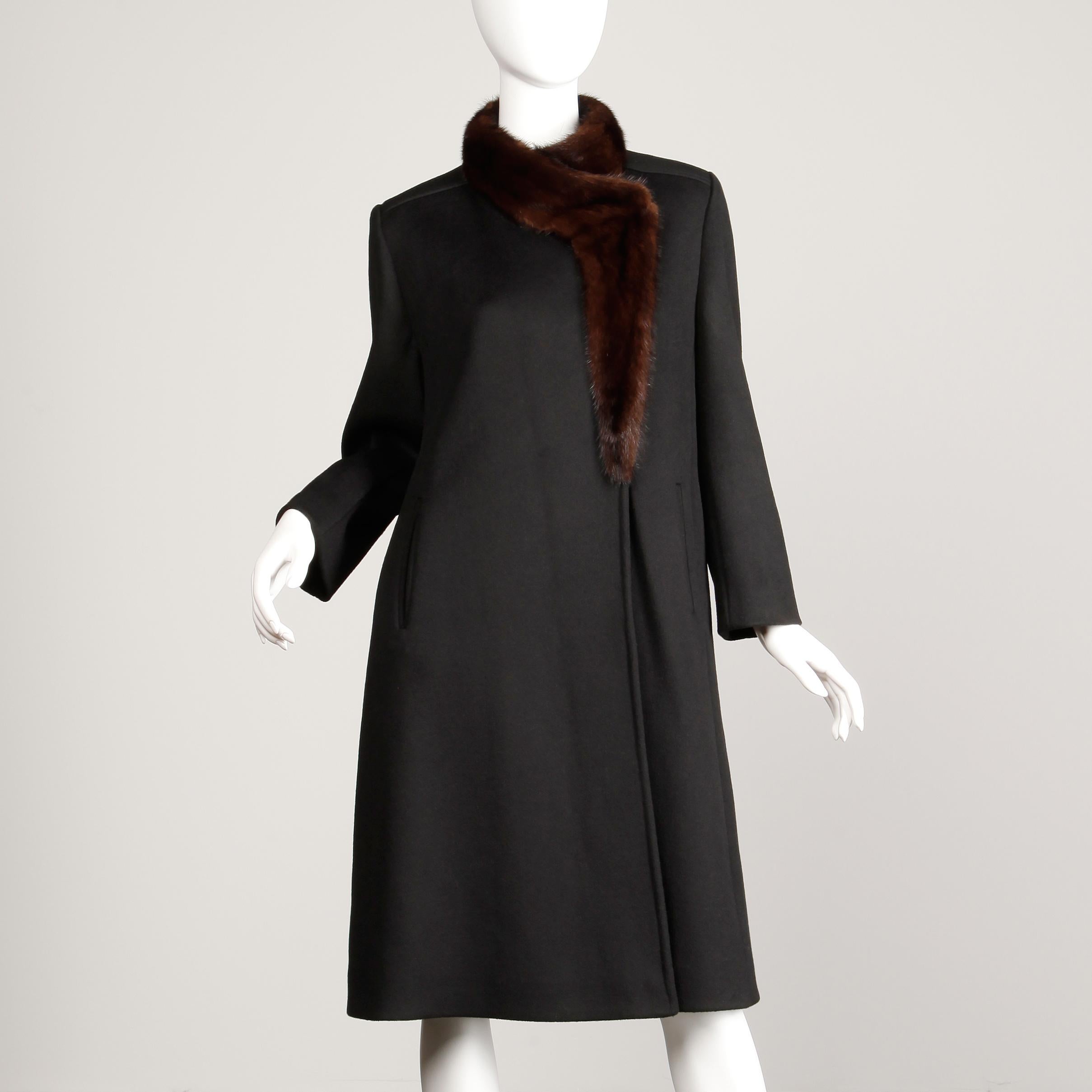 This one will never go out of style! Classic warm black wool coat with chic brown asymmetric mink fur collar. Fully lined with front button and snap closure. Hidden side pockets. 100% wool. Fits like a modern size medium. The bust measures 42.5