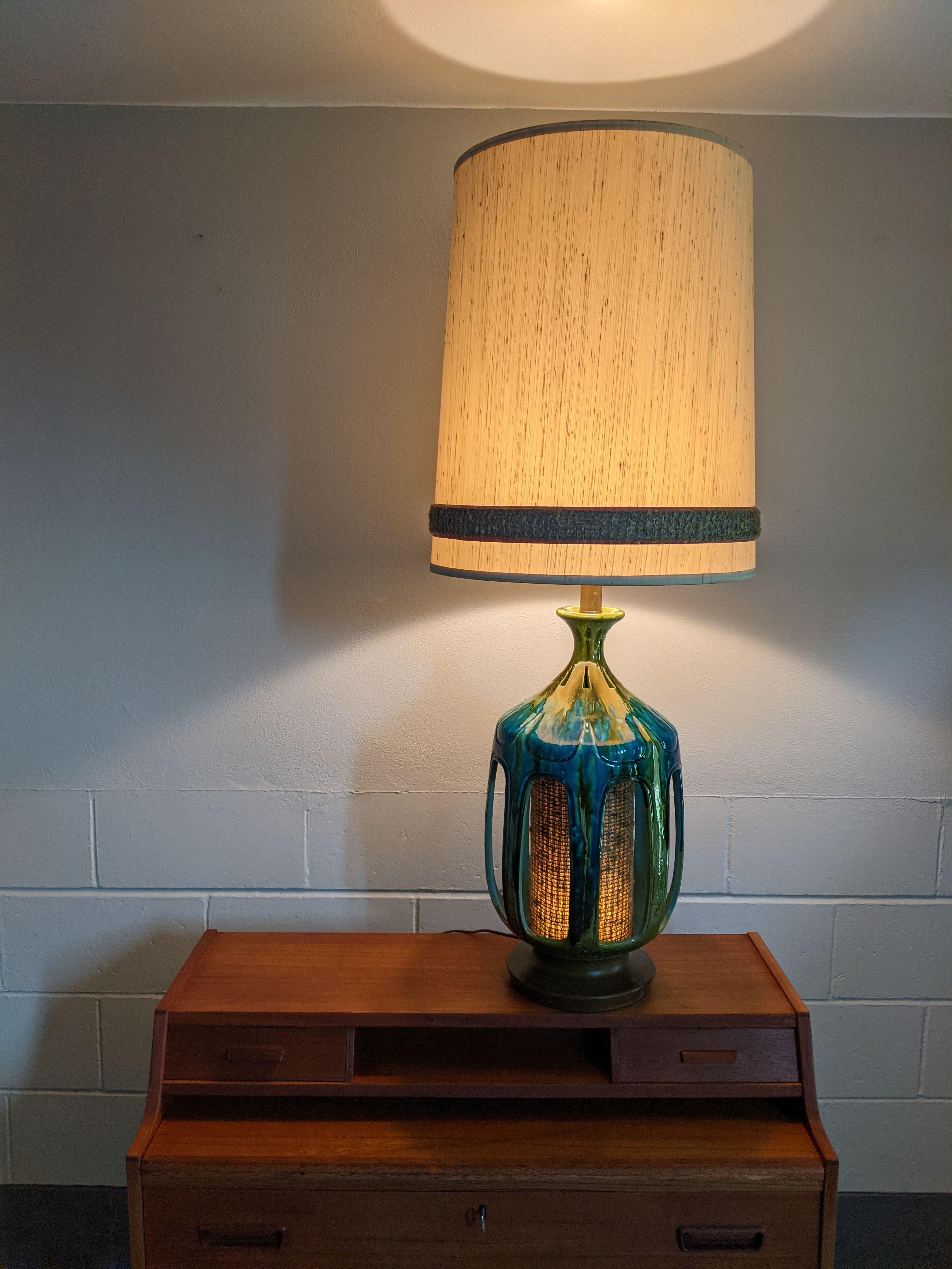 Large vintage Honi Chilo lamp with original shade, circa 1970s.

Blue/Green gloss drip glaze. Switches on base and neck, inside of base lights up with fabric to match the shade.

Excellent vintage condition. Very large vintage