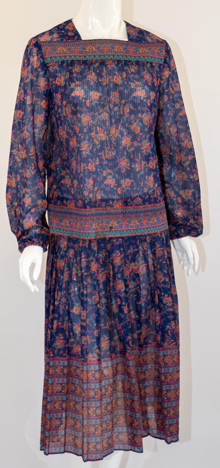 1970s Vintage Miss Magnin at I. Magnin.
1970s Joseph Magnin Bohemian floral printed blouse and skirt.
Printed bohemian dress featuring a floral print in violets and blues, this floral design pattern mixed together to create a stunning vintage