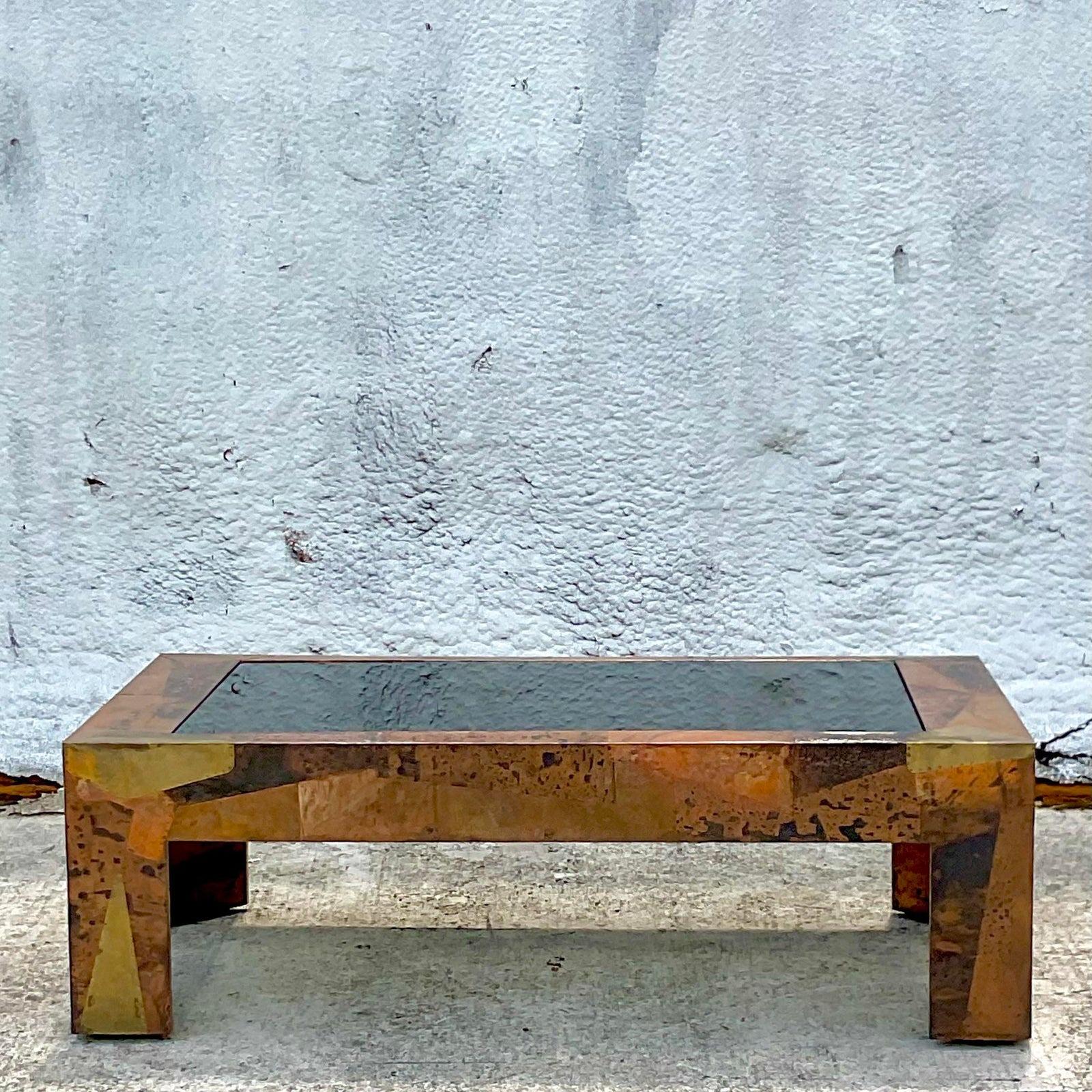 A fabulous vintage Boho coffee table. Done in the manner of the iconic Paul Evans. Beautiful patchwork panels of copper and brass. Inset smoked glass top. Acquired from a Palm Beach estate.