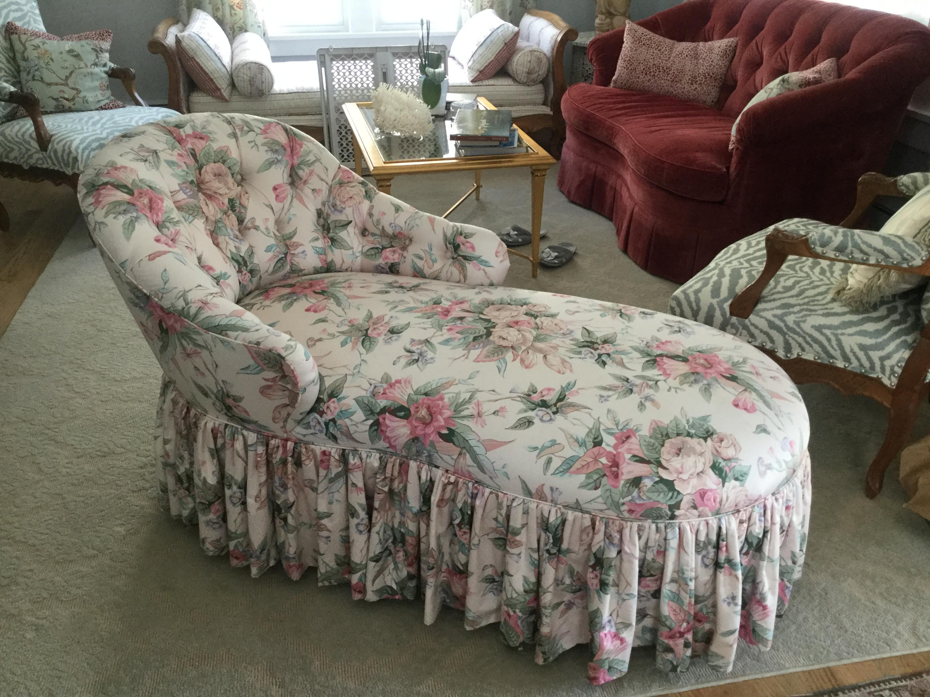 Romantic tufted-back chaise. This elegant chaise is upholstered in a tradition English cotton chintz featuring a soft floral pattern in many shades of pink and green on a white background. The back is tufted with covered buttons, and a full, shirred