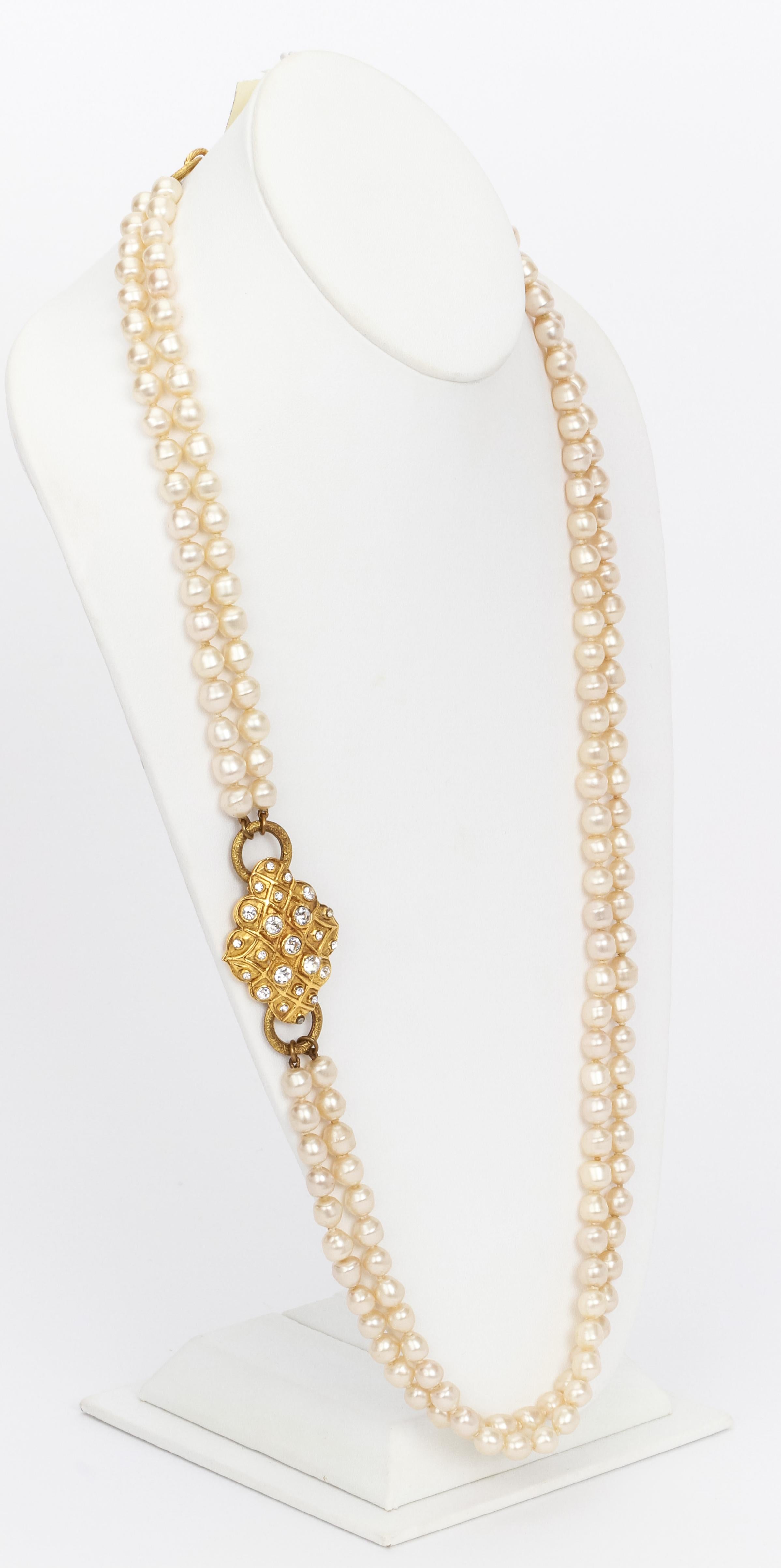 Chanel two strand pearl necklace with oblong decorative gold medallion featuring a quilted motif, each diamond shaped section decorated with a rhinestone in different sizes. Vintage 1970s in pristine conditions.
