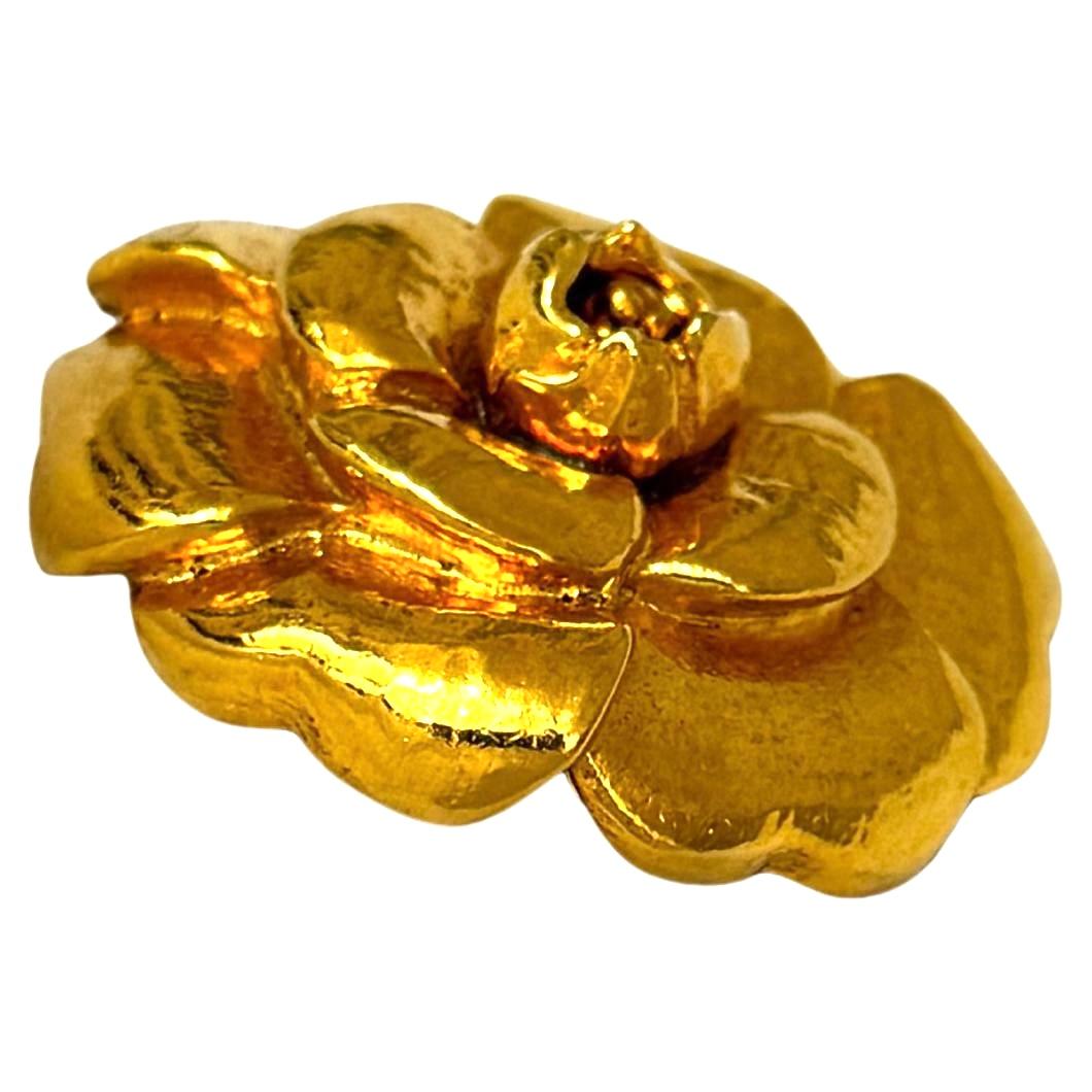 This vintage CHANEL gold toned camellia brooch is crafted of 24K gold plated metal. Stamped Chanel made in France. Diameter measures approximately 1.75 inches (4.5 cm) in diameter. Comes with original Chanel white box. 

Condition: Excellent vintage