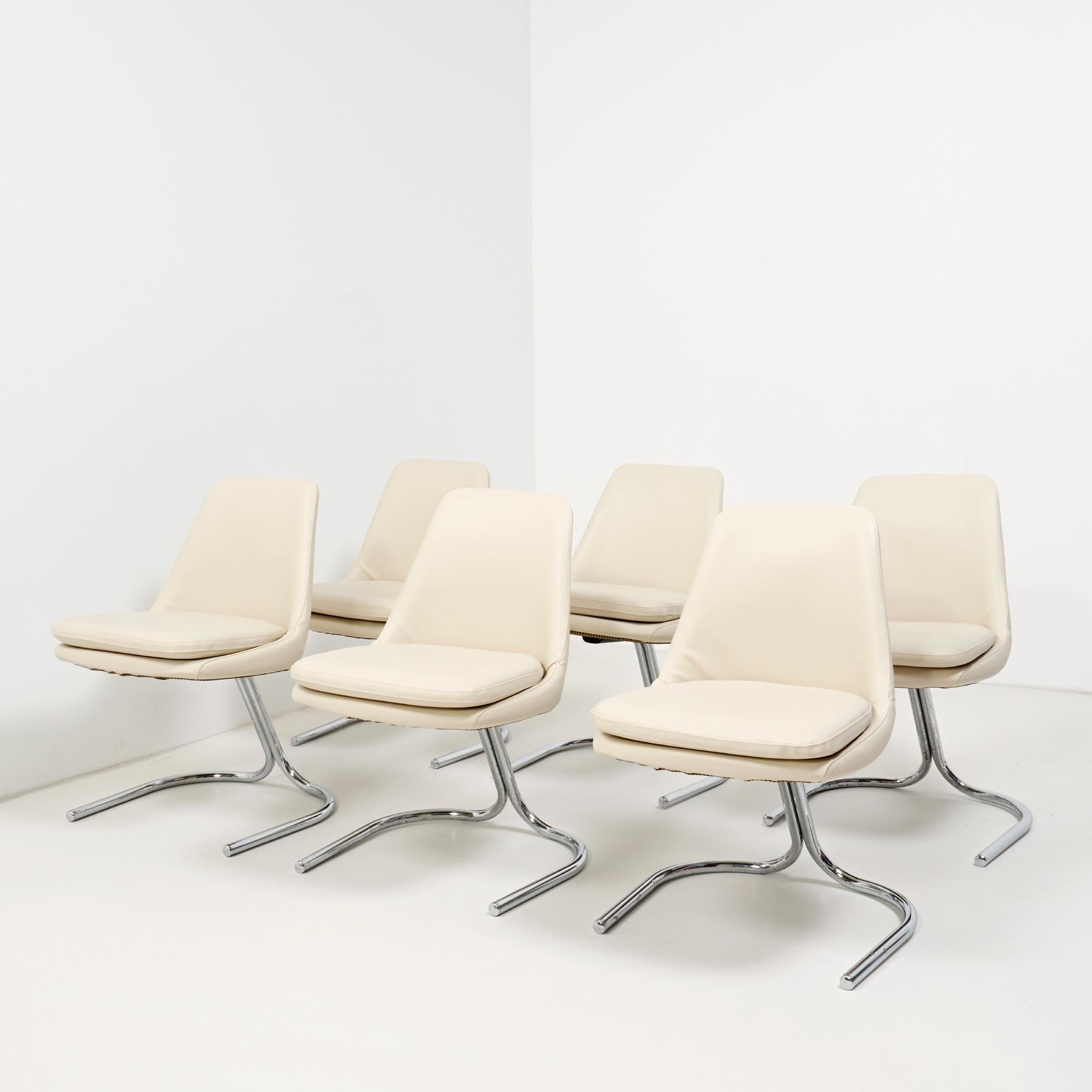 This striking set of 6 vintage Italian style dining chairs feature bucket seats with a unique U-shaped cantilever base.

The chairs have separate seat cushions and have been newly upholstered in cream leatherette, while the base is constructed