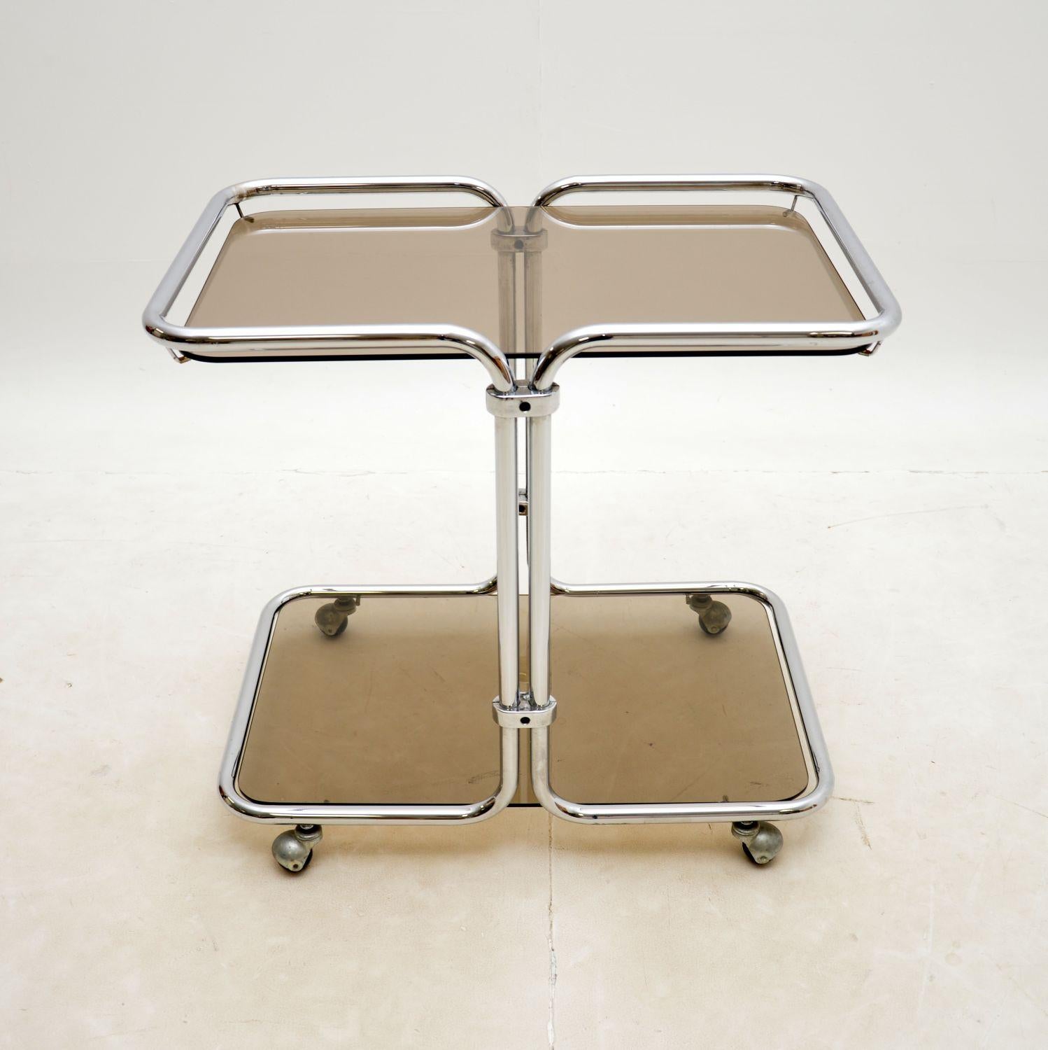 A very stylish and well-made vintage drinks trolley in tubular steel and glass. This was made in England, it dates from the 1970s.
It is of lovely quality and has a useful design. The top and lower tiers splay out from a central column base. This