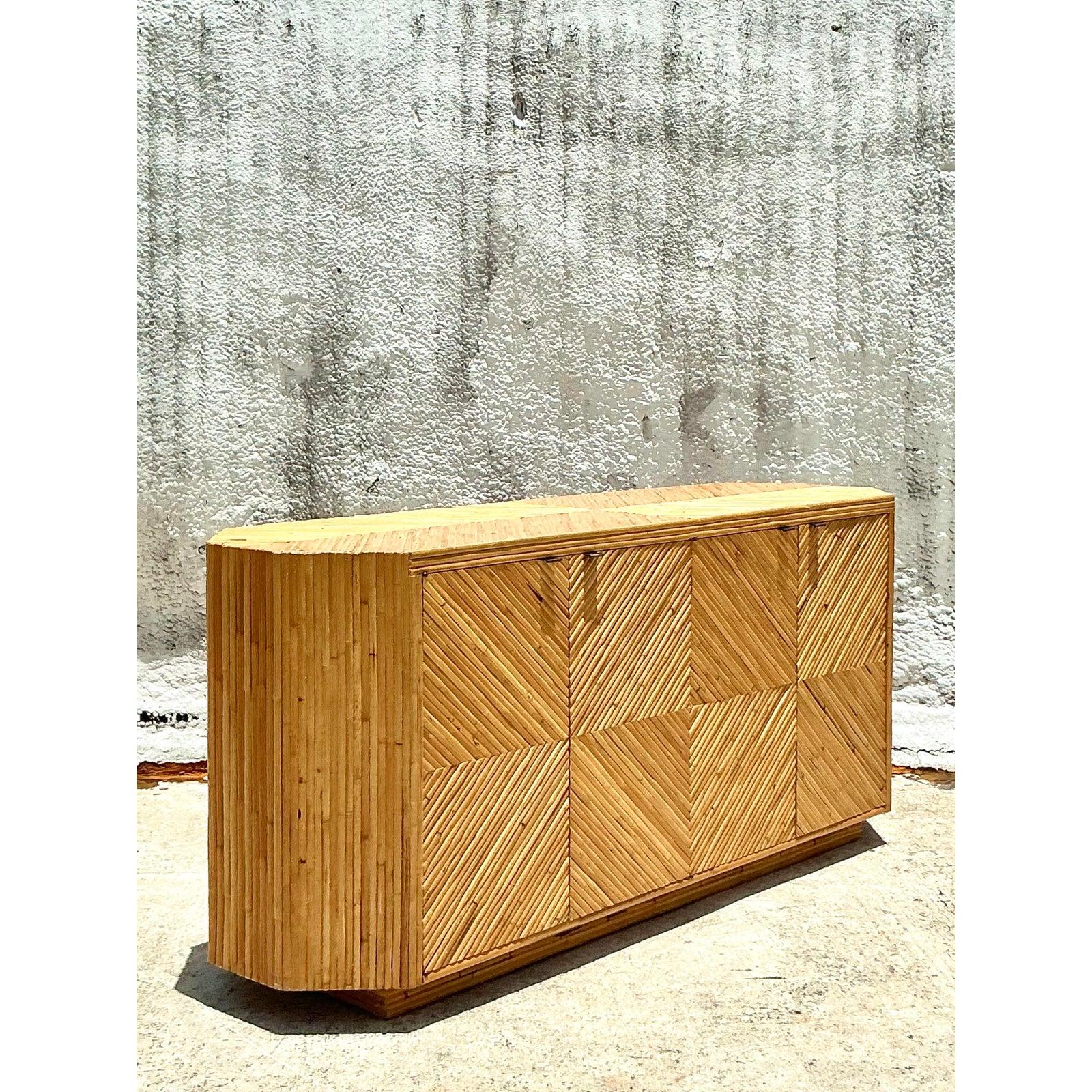 Adopta la sofisticación relajada y el encanto natural de esta Credenza Vintage Coastal Chevron de ratán. Esta pieza, un asombroso ejemplo de diseño moderno orgánico, presenta ratán meticulosamente aplicado a mano que forma un cautivador dibujo de