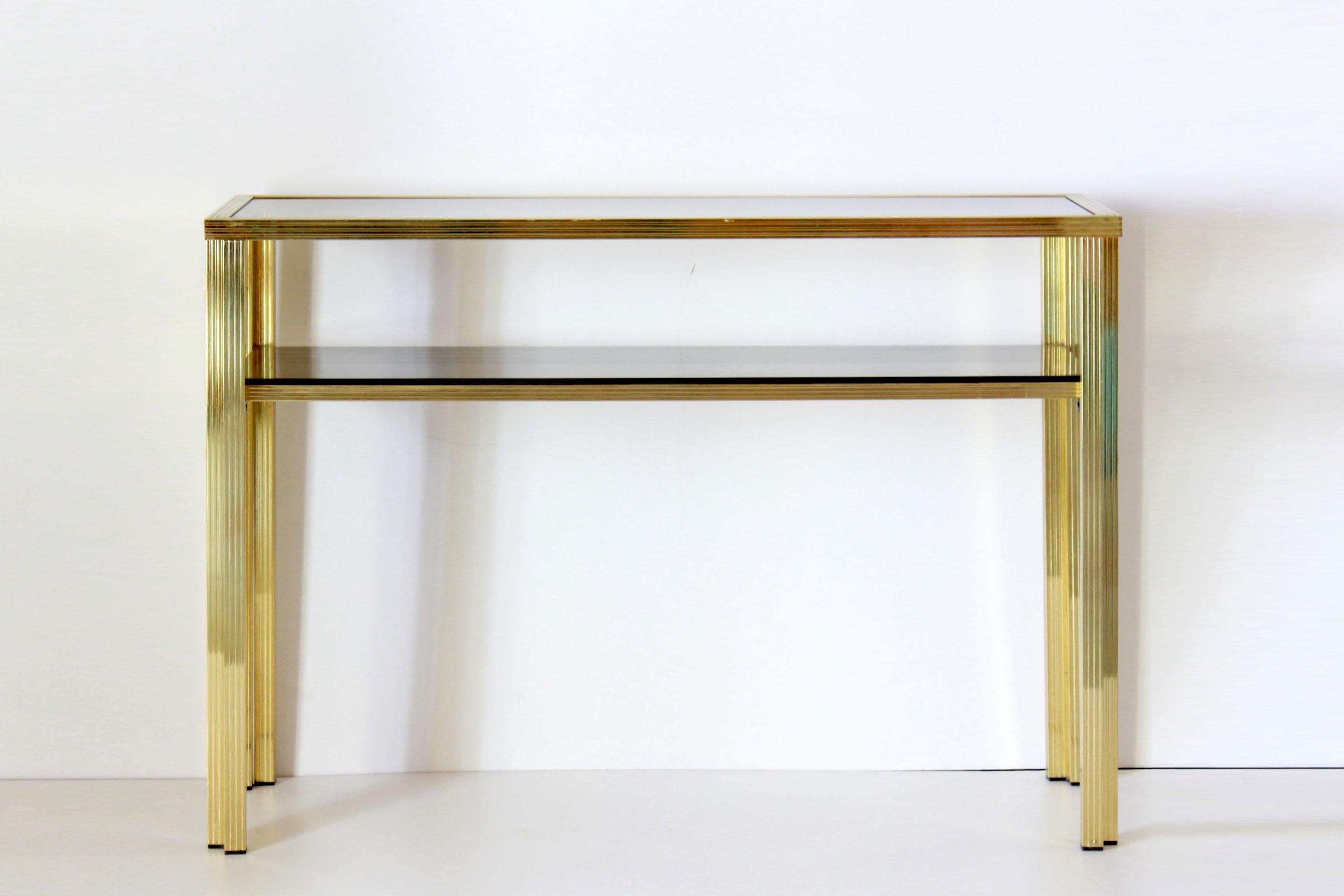 A 1970s vintage consolle table with dobule smoke glass tops and refined goldenrod iron structure. In very good conditions with only few signs of time.

Part of an house entrance set composed also by mirror, and console table. Items can be bought