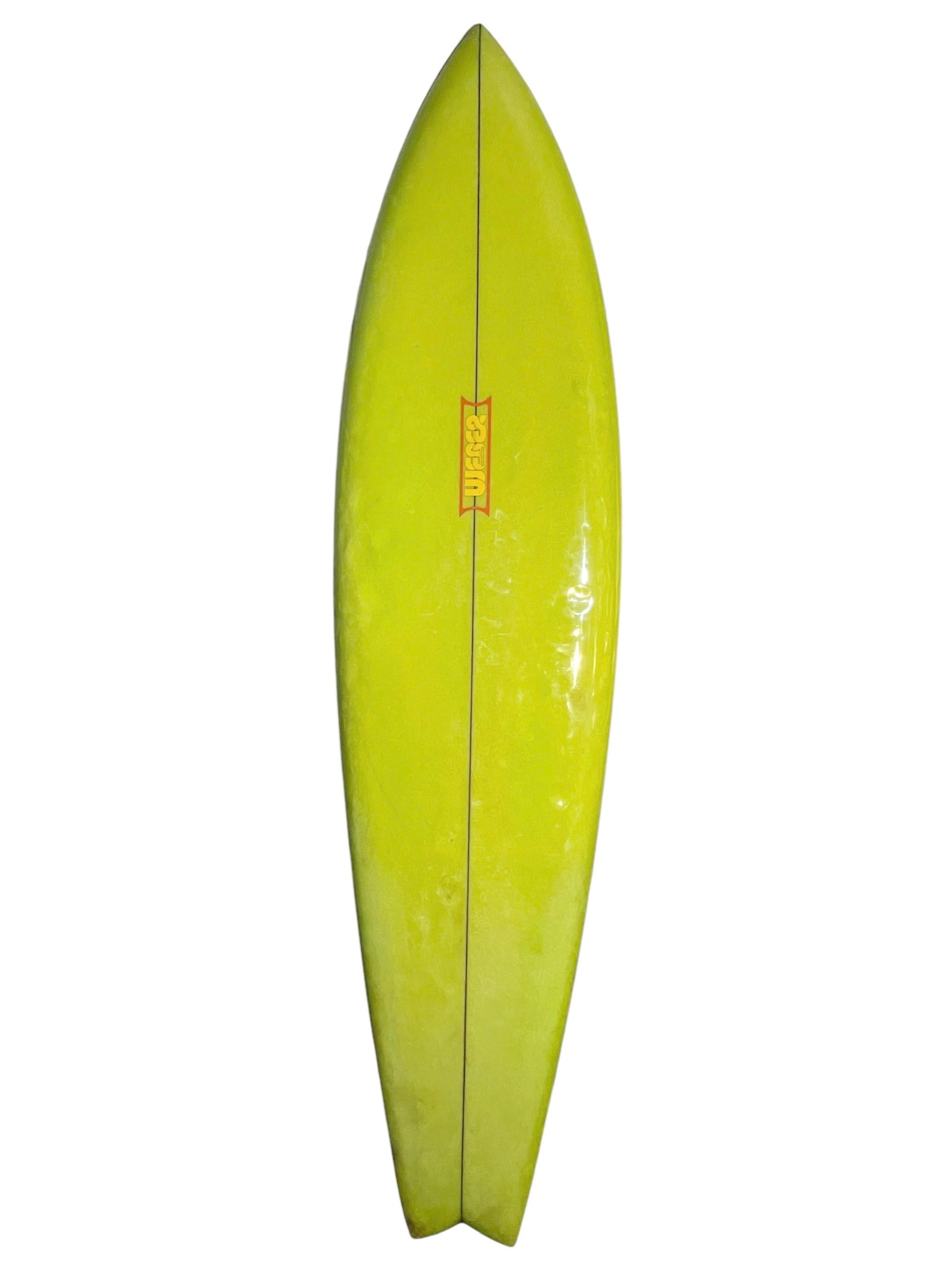 Vintage 1970s Dewey Weber wave mural surfboard. Features beautiful airbrushed full length wave mural on the deck with greenish yellow tinted rails/bottom. Swallow tail shape design. A stunning example of an original 1970s airbrushed surfboard work