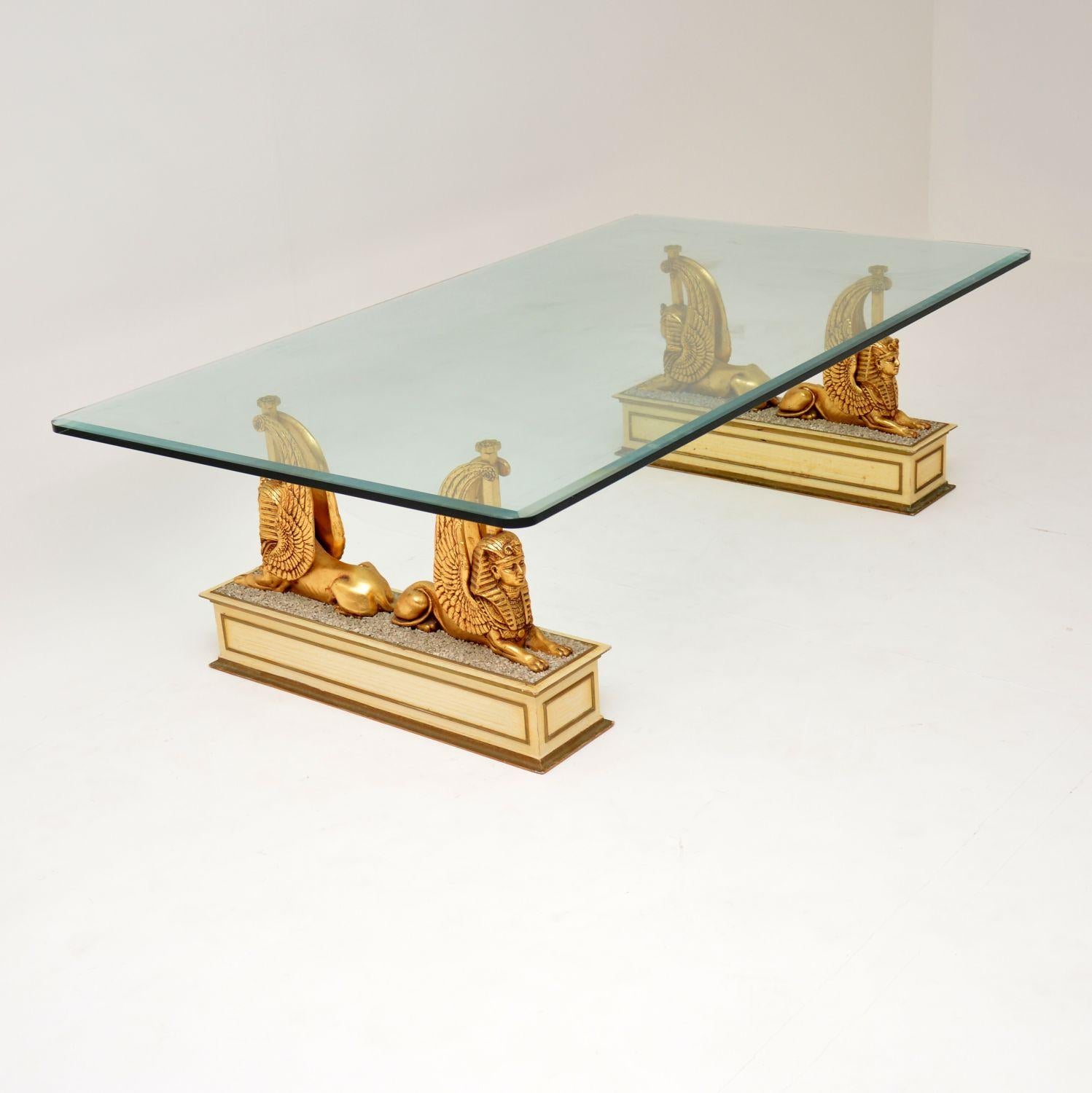 A stunning vintage coffee table, dating from the 1970’s. This has a thick, bevelled glass top, supported by two beautiful pedestal bases. The bases are carved gilded wood in the images of Sphinxes. This is of super quality and is in excellent