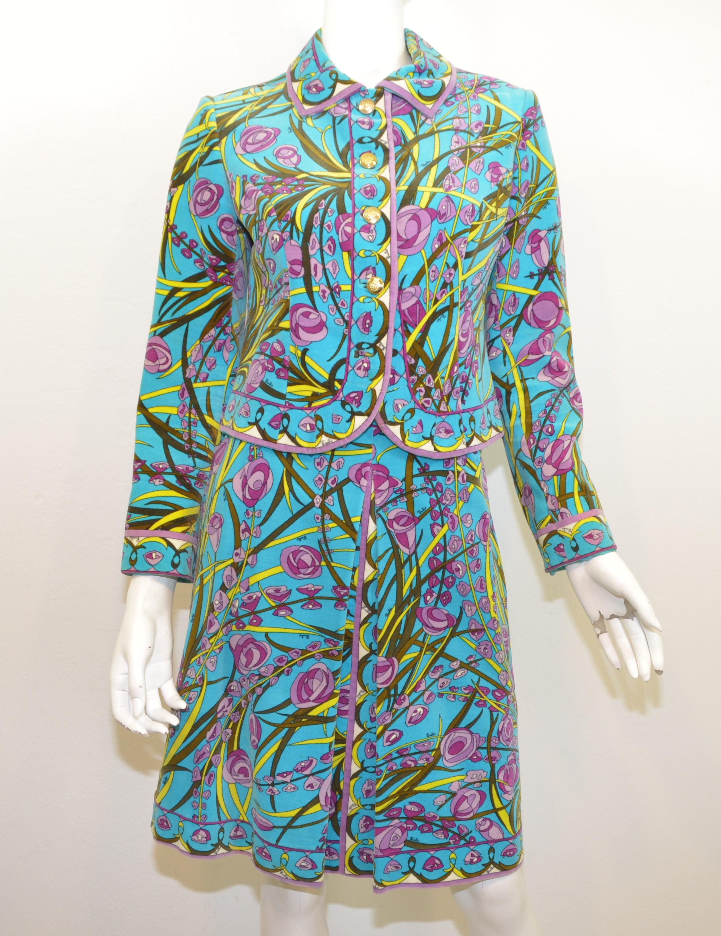 Vintage 1970's Emilio Pucci velvet cotton skirt and jacket set is featured in a vibrant blue with a purple, green, and yellow floral print throughout. Jacket is labeled size 10 with gold-tone button closures along the front (one missing as