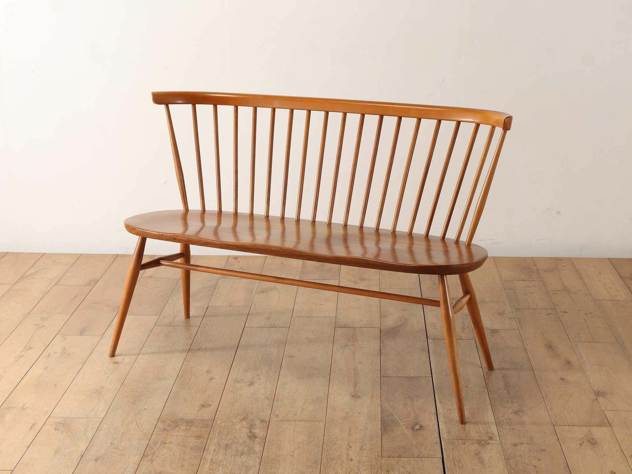 The Ercol loveseat is a representative of UK modernity and is still a popular brand founded by designer Lucian R. Ercolani in 1920. The smooth form of the seat, made of hard, bend-resistant elm wood with smooth corners, fits tenferly against the