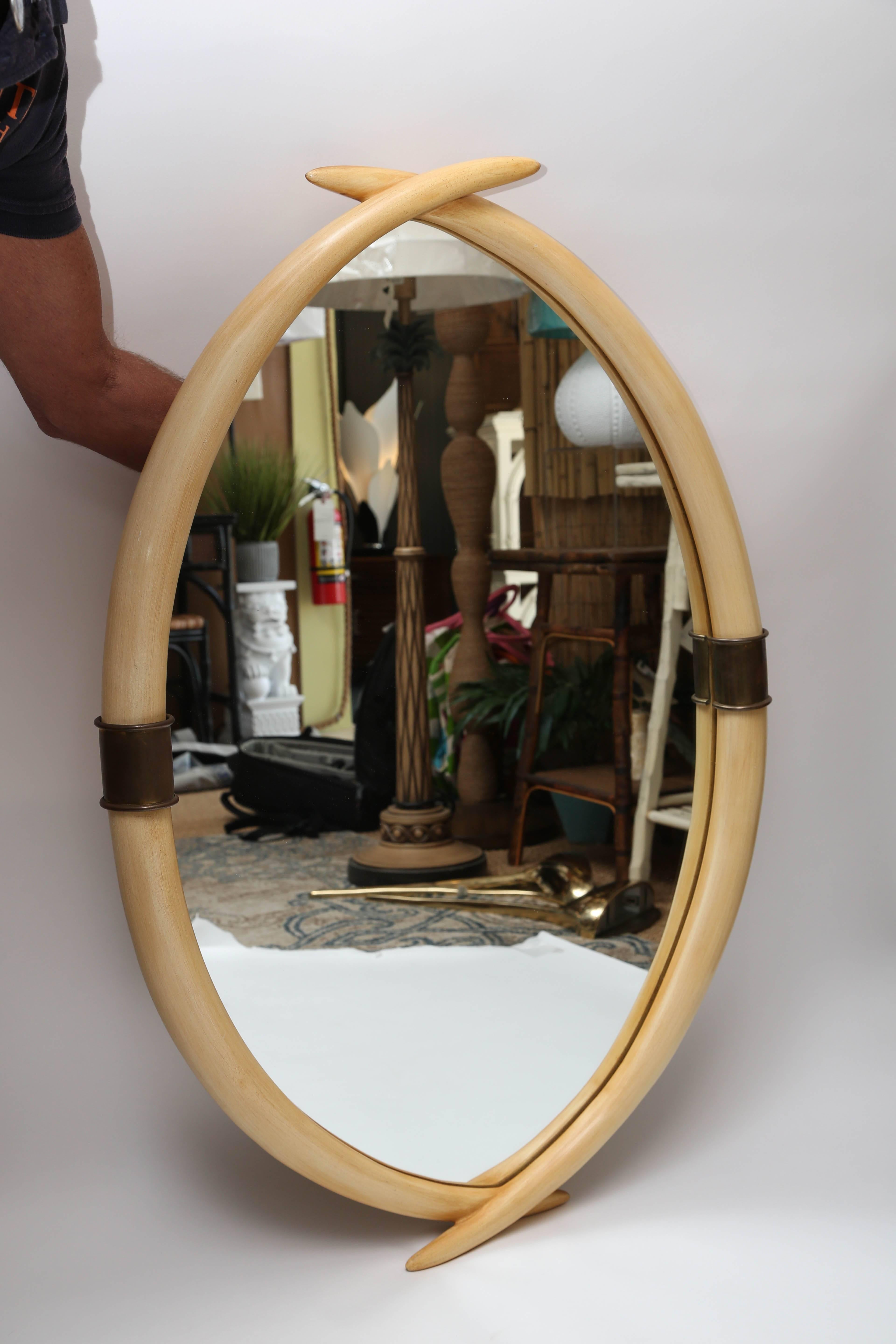 Faux mirror by E.F. Chapman, circa 1970s. Overlapping tusk design of wood with brass accents define this unique and elegant mirror.