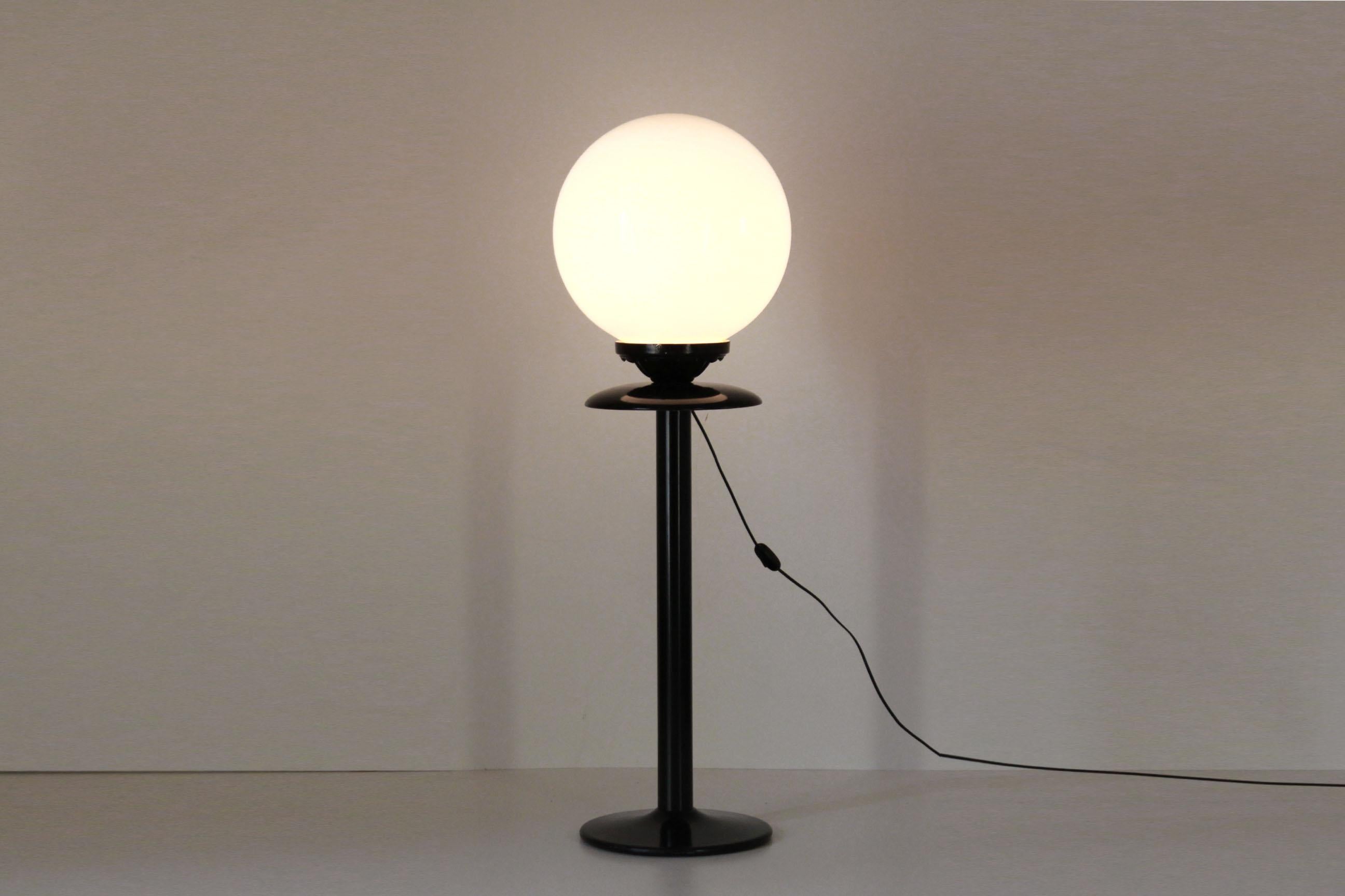 A 1970s vintage floor lamp with wood and iron black structure and plastic light globe. E27 light globe. In very good conditions with only few signs of time.