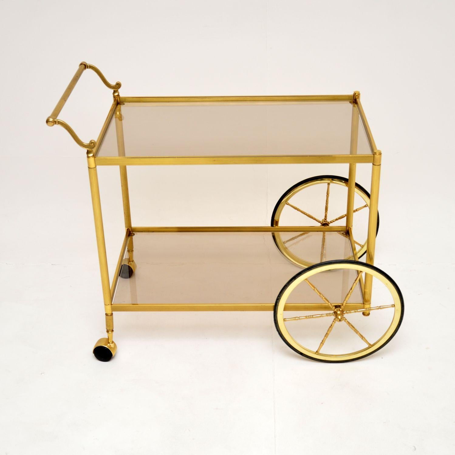 Chariot à boissons / chariot de bar en laiton et verre, très élégant et utile, datant des années 1970.

La qualité est fantastique, ce modèle est de grande taille et est magnifiquement conçu, avec des supports en laiton cannelé, une poignée en