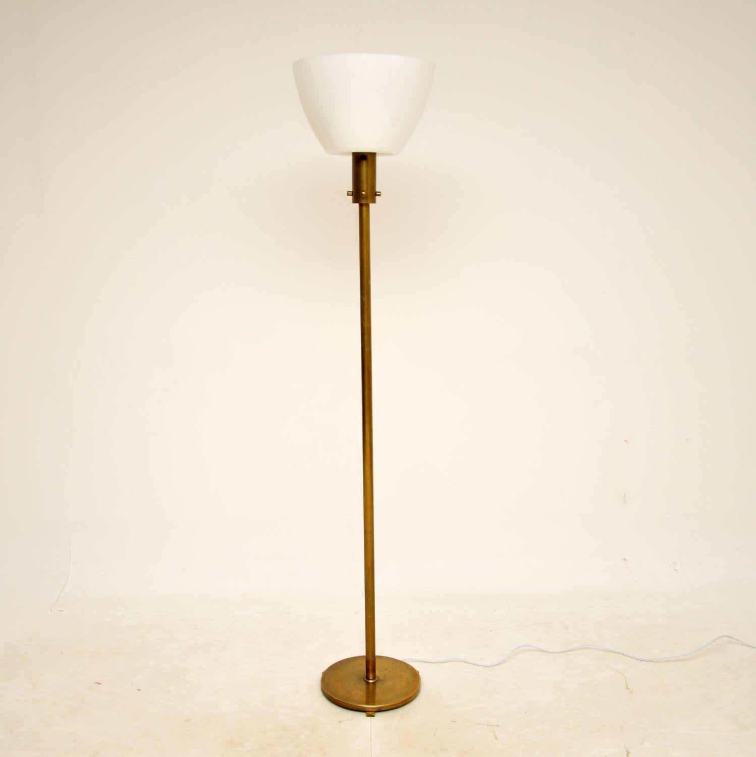 A beautiful and very stylish vintage French up-lighting floor lamp in brass, with a stunning white glass shade. This was recently imported from France, it dates from the 1970s.

The quality is superb, the thick brass frame is very well made and