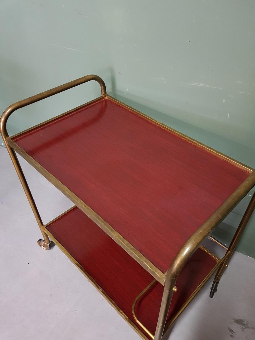 Vintage French serving cart or trolley with brass frame and formica trays and at the bottom there is a bracket to use bottles, it is in good condition with light user marks. Originating from the 1970s.

The measurements are:
Depth 38 cm/ 14.9