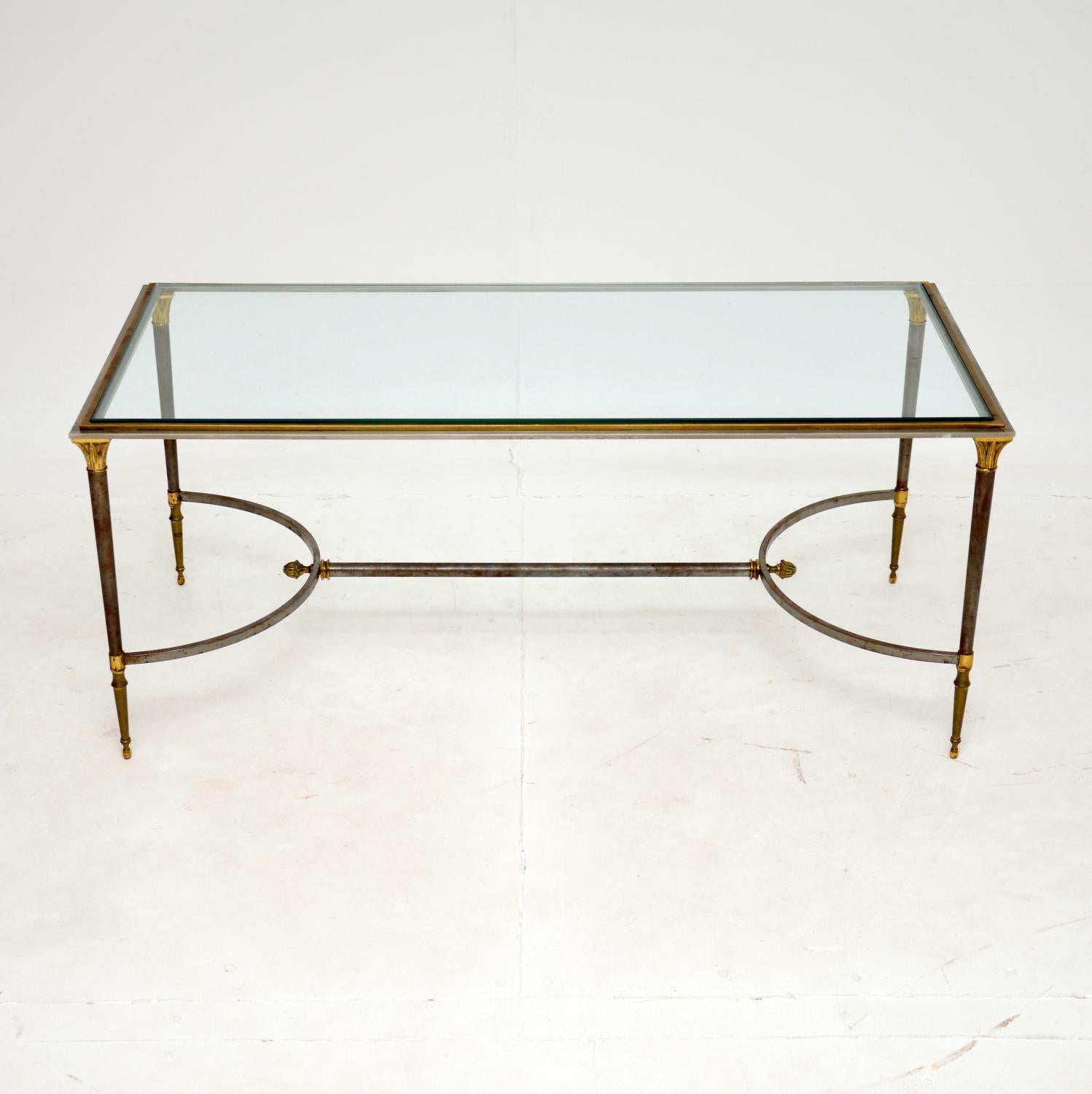 Une superbe table basse vintage de très grande qualité. Fabriqué en France, il date des années 1970.

Le cadre est en acier avec un bord en laiton autour de la partie supérieure et des embellissements en feuilles d'or sur la base. Il présente de