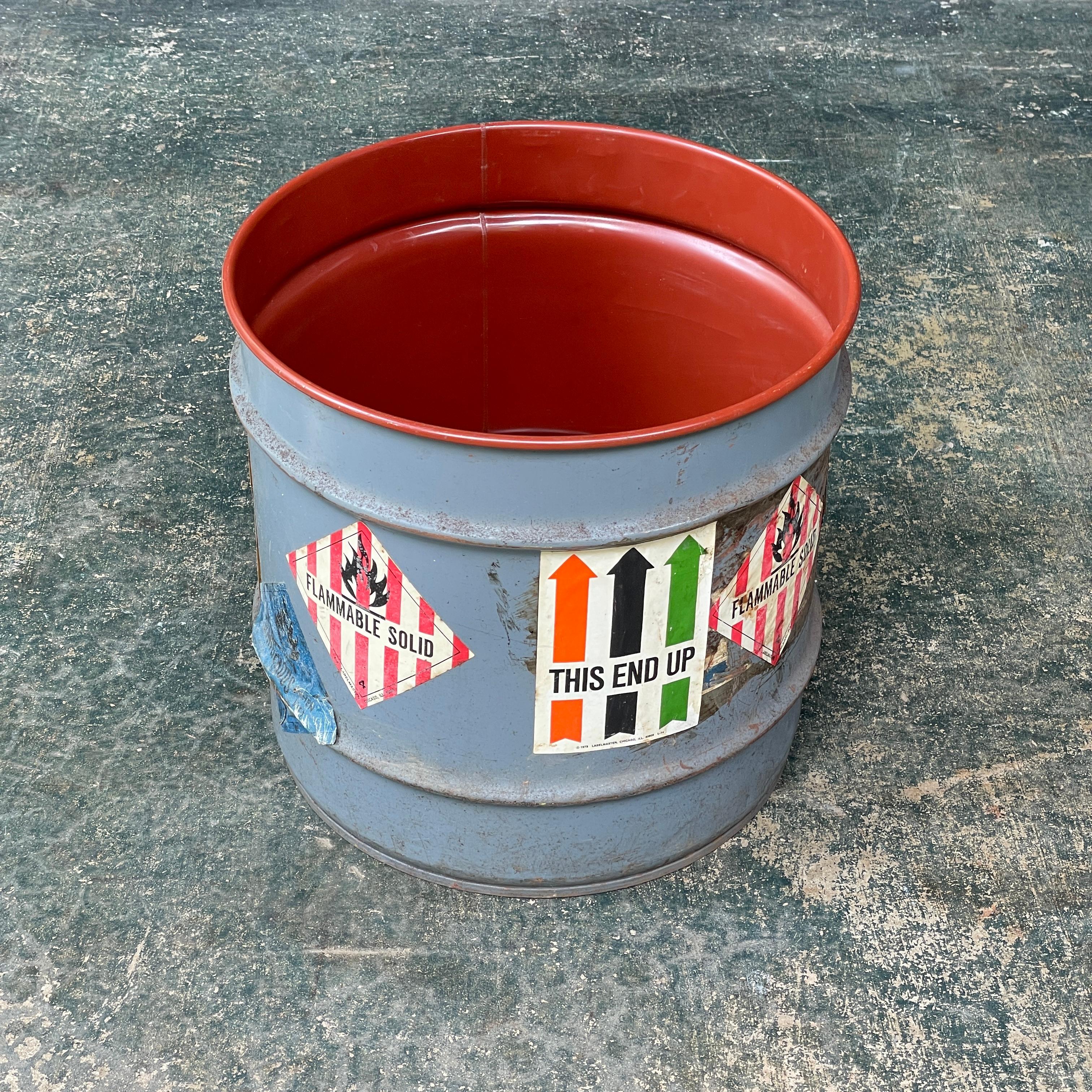 Fusto colorato in acciaio per olio/chimica, pulito all'interno e recentemente acquistato da un collezionista di auto. Decalcomanie datate 1973.  Pulito all'interno.
L 15 x P 15 x H 14