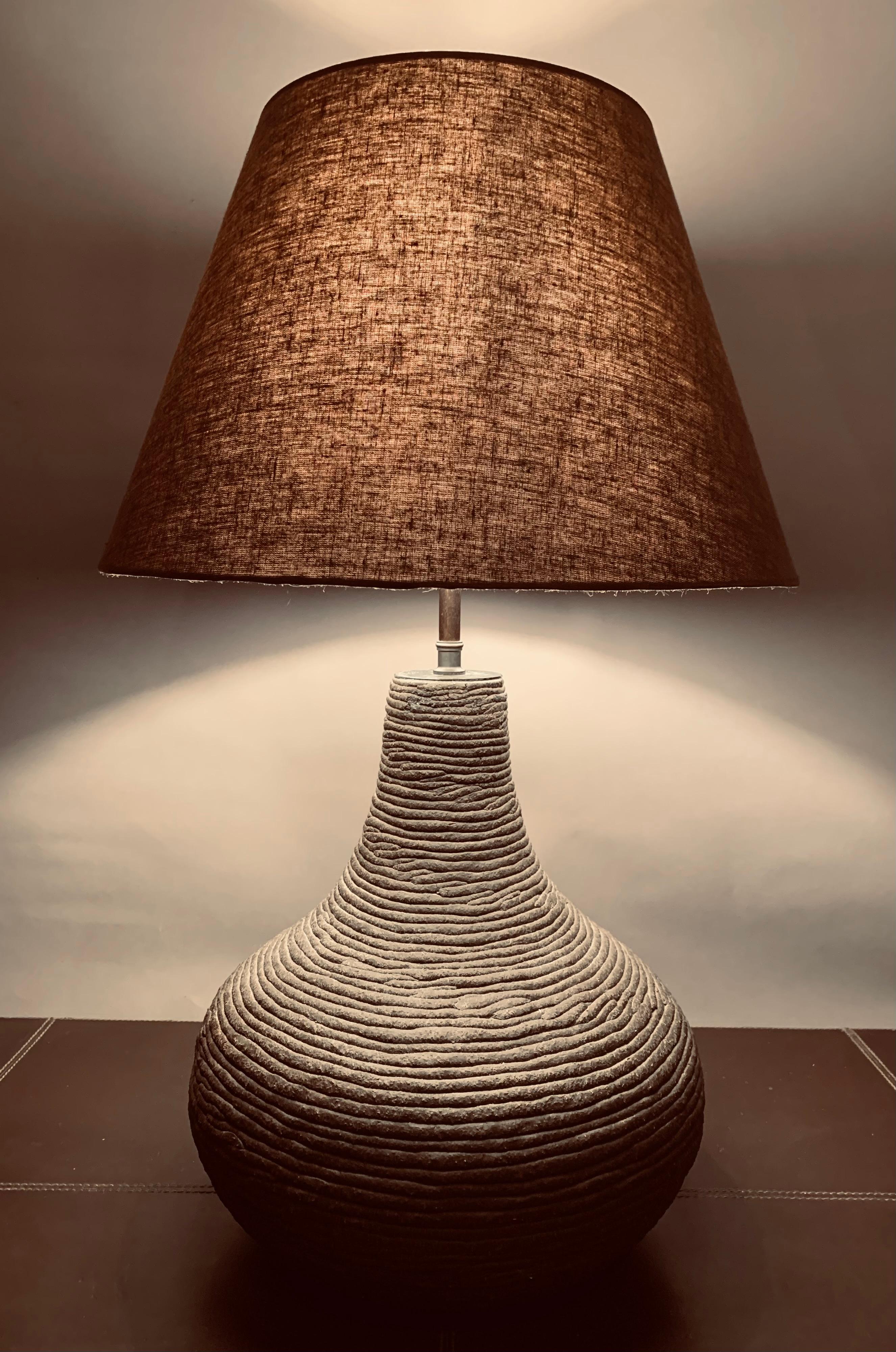 1970s German handcrafted matte chocolate brown pottery table lamp. The table lamp is interestingly constructed from very thin clay coiled into a bulbous shaped lamp, fired and glazed.

The lamp is fitted with an antique brass bulb bayonet bulb