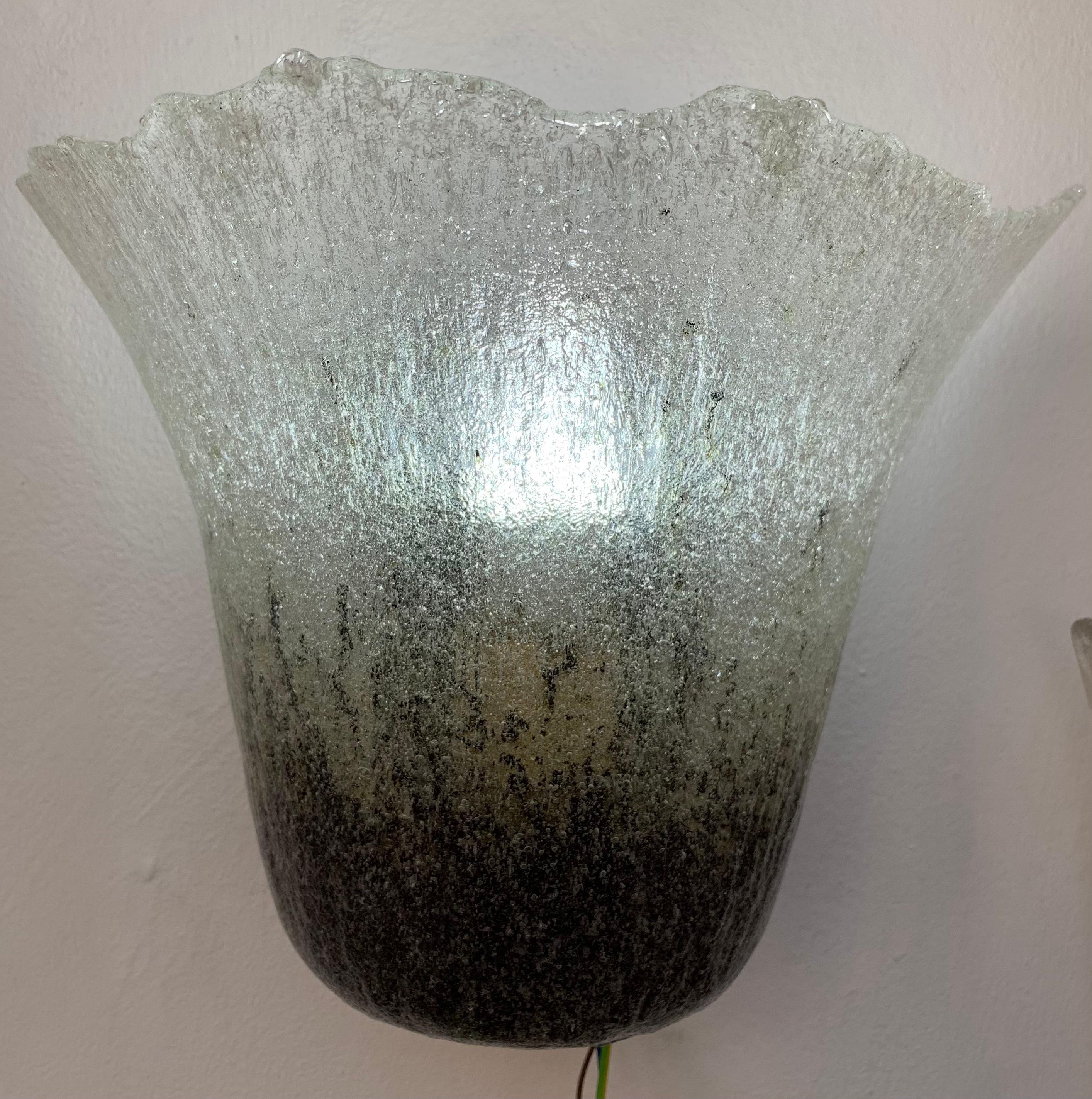 A single 1970s German wall sconce manufactured by Peill and Putzler. The thick Murano glass shade is secured onto the gold tinted metal frame with a lacquered black metal fitting which it slots into and is secured in place with a feature brass screw
