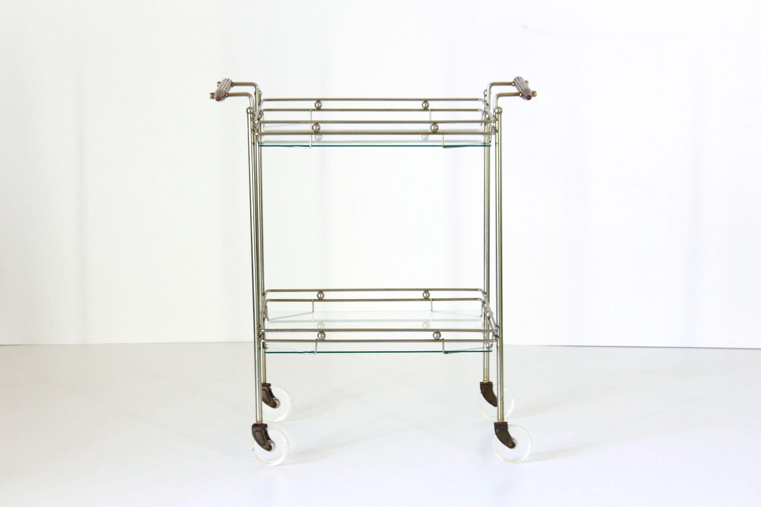 A rare 1970s vintage bar cart with rolling wheels and brass and glass structure. In very good conditions with only few sign of time.
