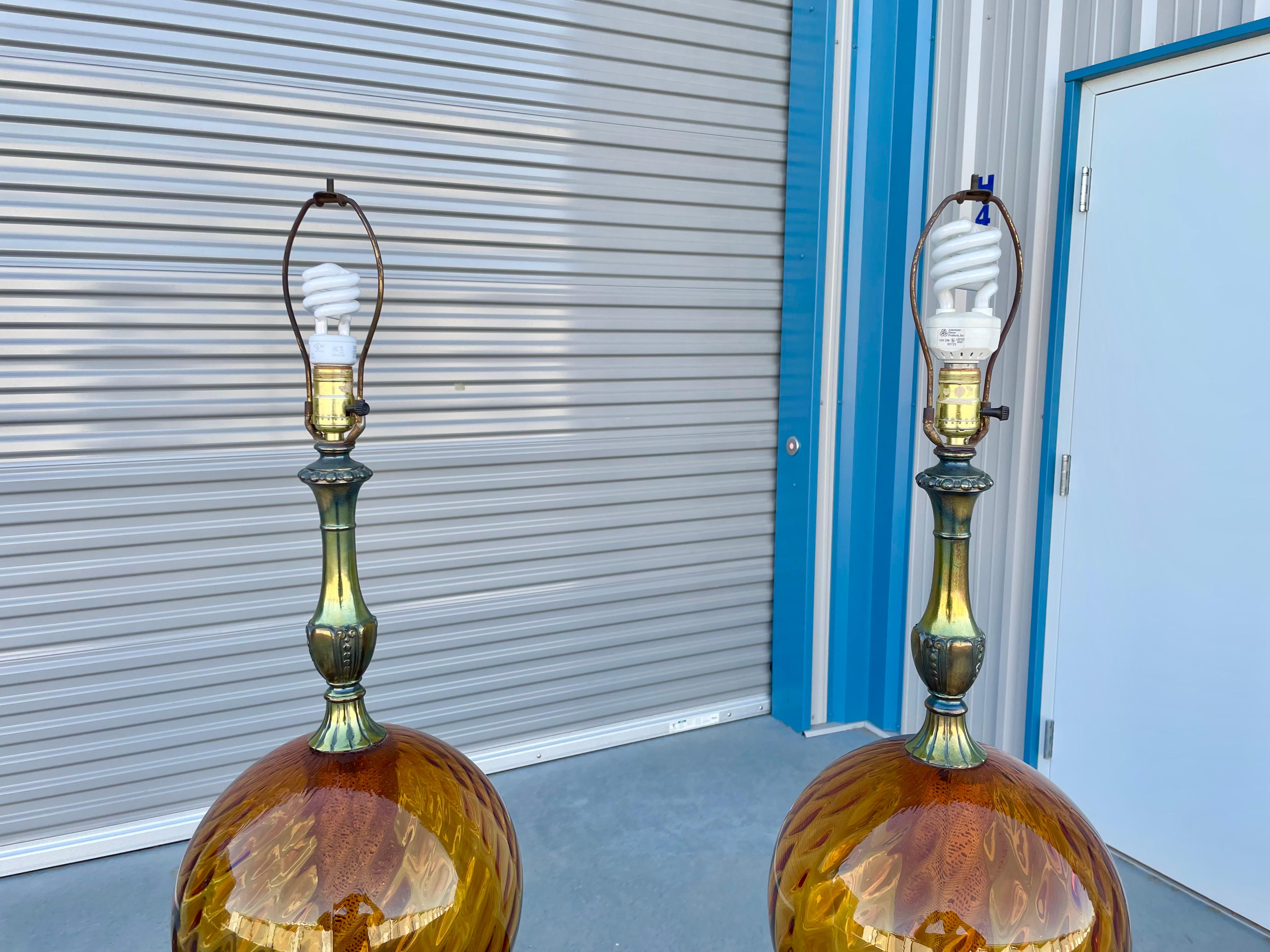 Vintage Paar Glaskugellampen, entworfen und hergestellt in den Vereinigten Staaten, ca. 1970er Jahre. Diese schönen Vintage-Lampen haben ein kugelförmiges Glasdesign auf einem Metallsockel, das ihnen einen eleganten Vintage-Stil verleiht. Die