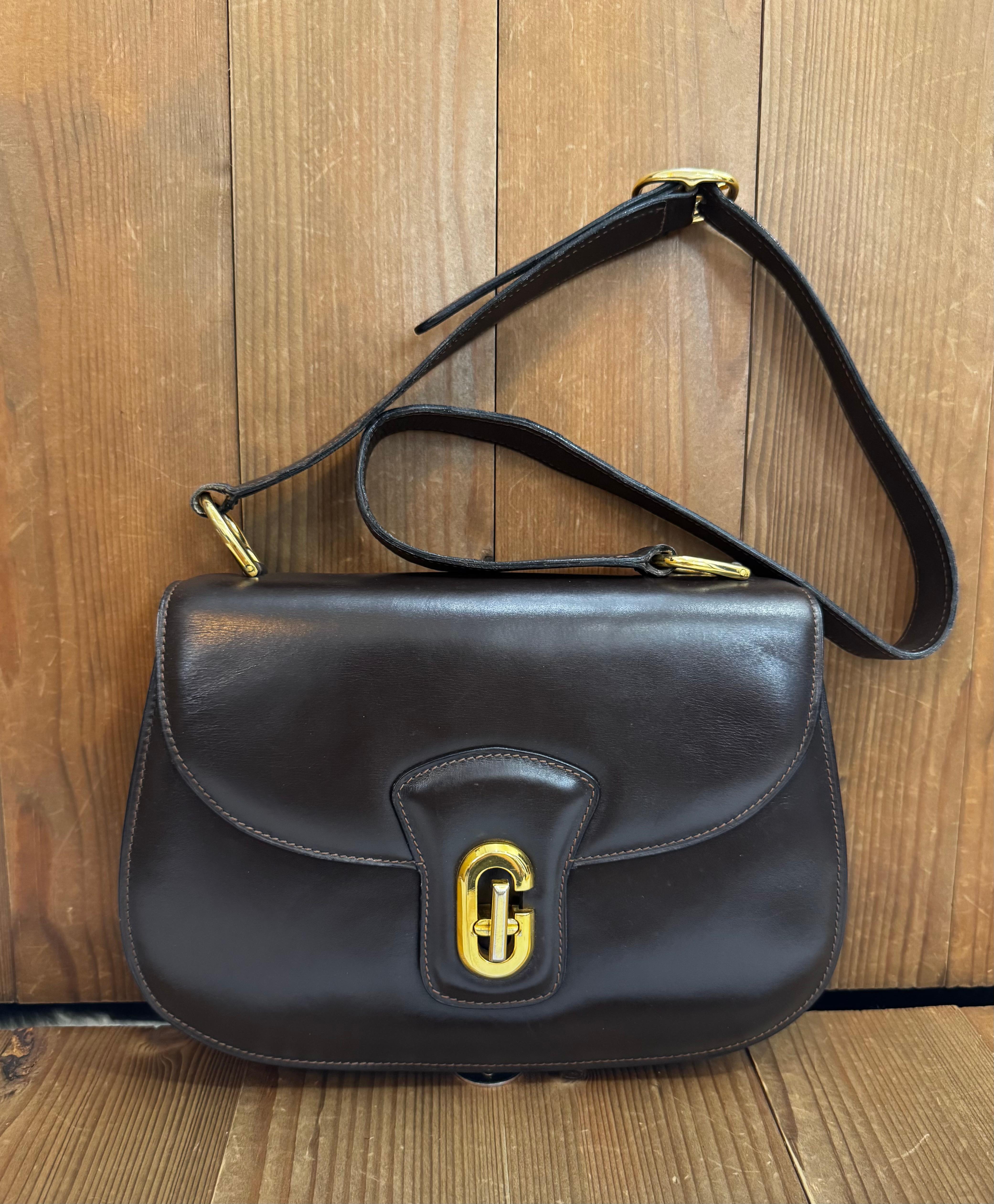 This vintage GUCCI Boutique shoulder bag is crafted of calfskin leather in brown featuring gold toned hardware. Front flap G turnlock closure opens to a main compartment featuring a zippered and a patch pocket. Three-hole adjustable shoulder strap.