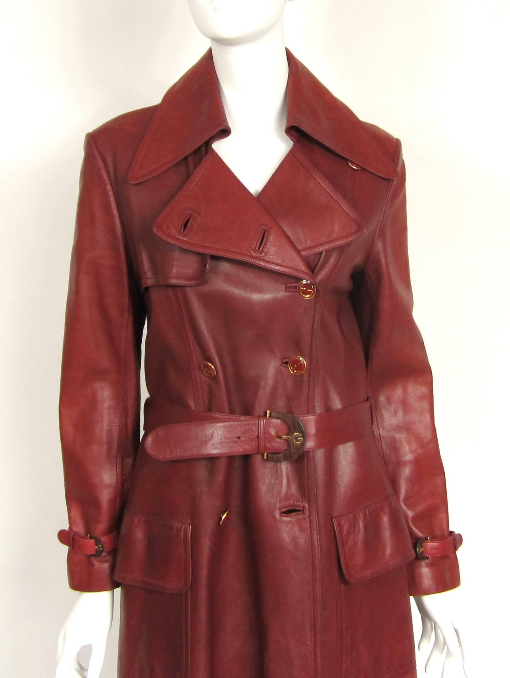 Timeless Burgundy Gucci Leather Trench Coat, featuring Gucci Logo Buttons and a stunning Gucci Lining. Butter Soft Leather. Kick Pleat in the back. Double Breasted with a great pointed collar. Patch front pockets. Labeled a size 48. Will fit a 4-6.
