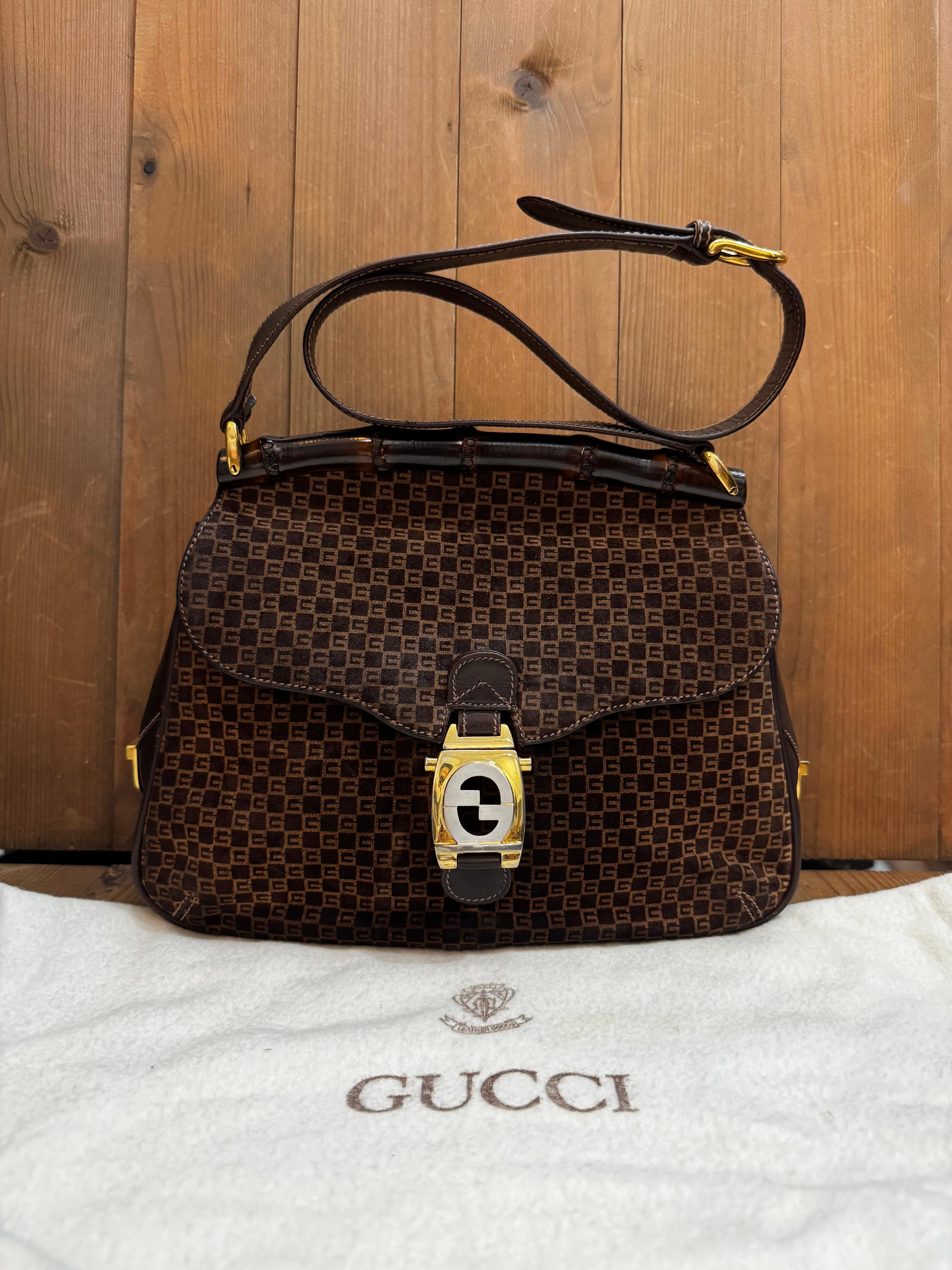 Questa rarissima borsa a tracolla vintage Gucci in bambù è realizzata in nubuck con monogramma GG e pelle di vitello liscia di colore marrone con finiture in oro/argento. La patta frontale con chiusura push-lock GG in tonalità oro/argento si apre su