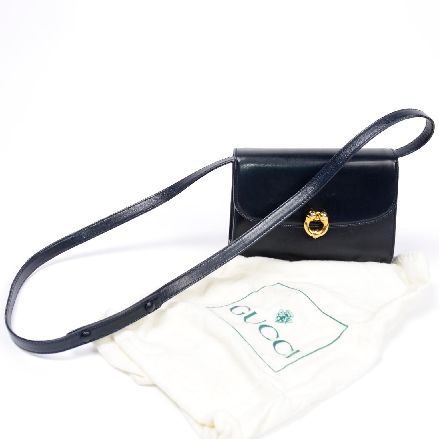This is a classic Gucci vintage deep navy blue midnight leather handbag with a long shoulder strap and gold hardware.  This timeless bag can be worn as a shoulder bag or cross body. We love the gold ball clasp and the Gucci signature vintage red