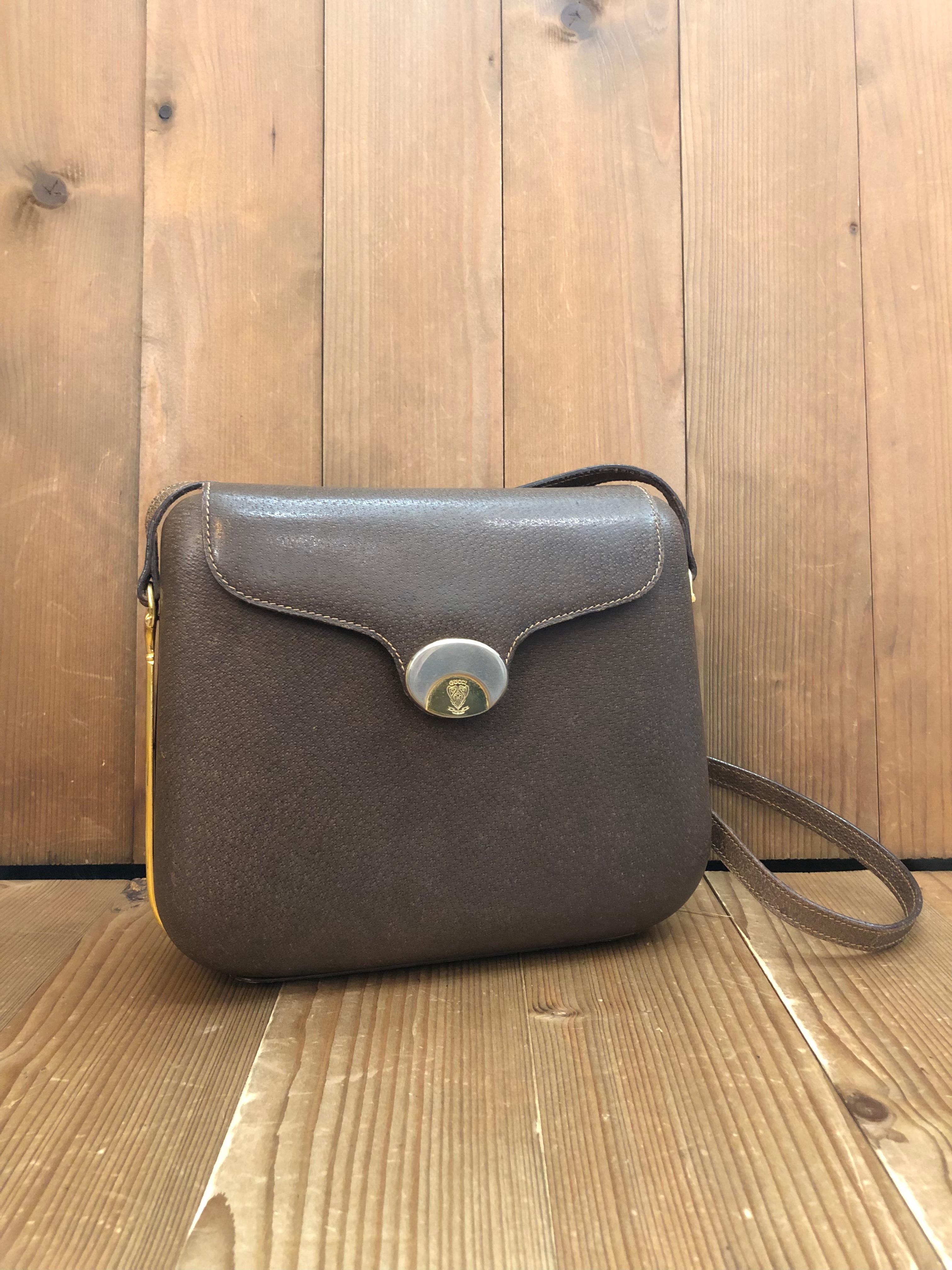 This rare vintage GUCCI hard-shell crossbody bag is crafted of pigskin leather in brown featuring a beautifully structured body with gold/silver toned hardware. Front magnetic snap closure opens to a beige leather interior featuring a patch pocket.