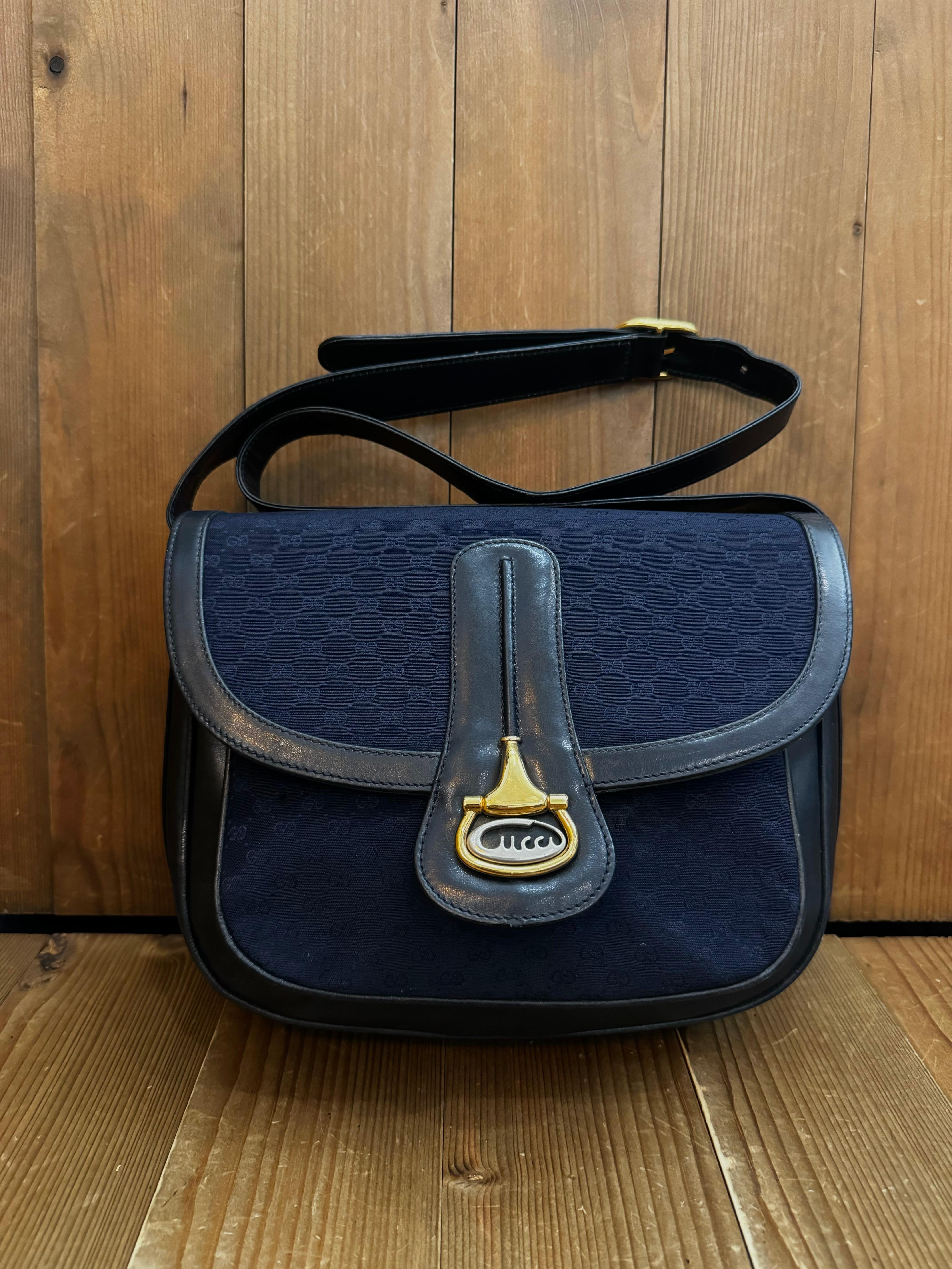 This Vintage GUCCI shoulder bag is crafted of micro GG jacquard in navy trimmed with smooth leather in navy featuring gold and silver toned hardware. Front snap flap closure opens to a fabric interior featuring a zippered pocket and a front pocket.