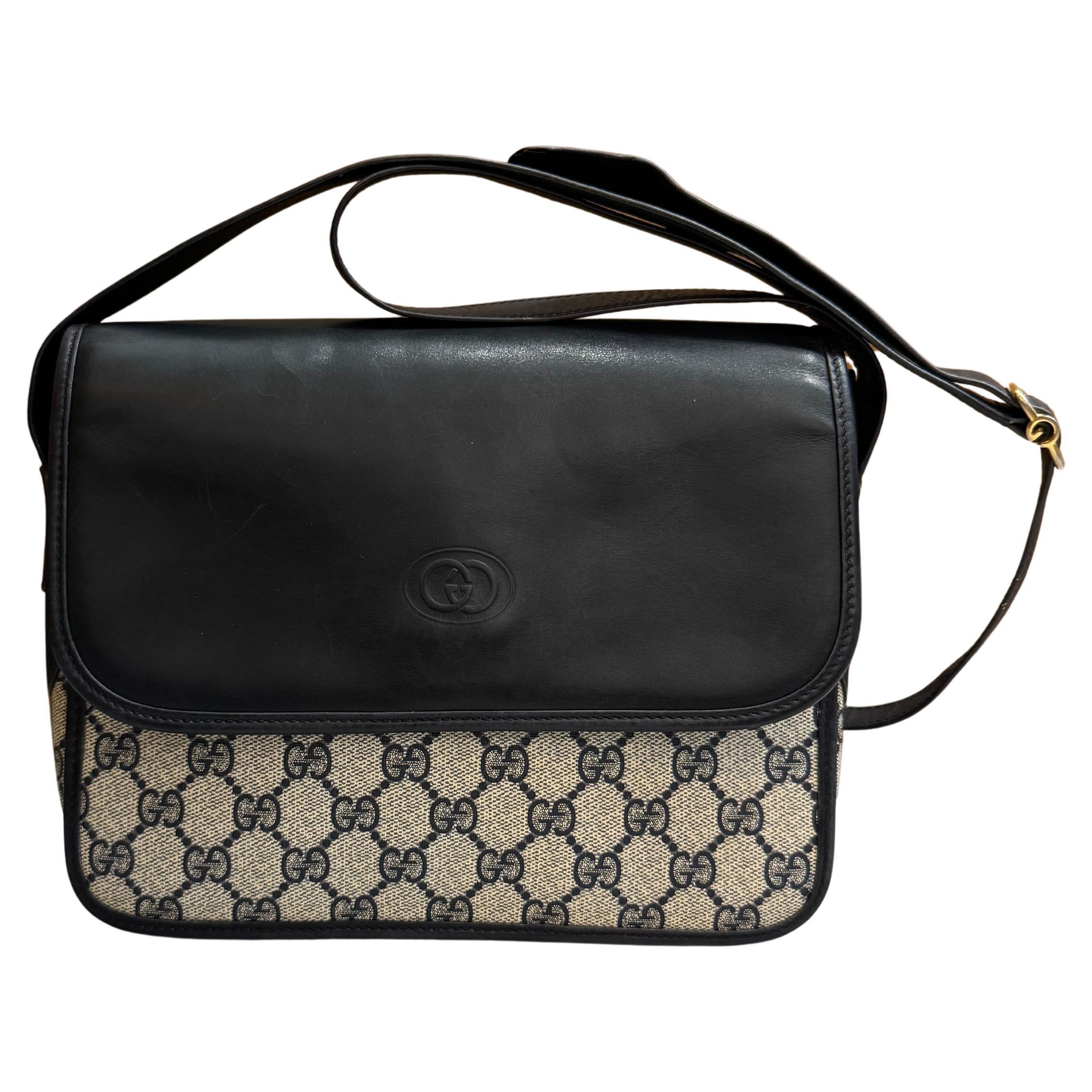 This vintage GUCCI crossbody bag is crafted of GG monogram coated canvas and smooth calfskin leather in navy featuring perforated GG logo on the sides. Front flap magnetic snap closure opens to coated interior which has been professionally cleaned