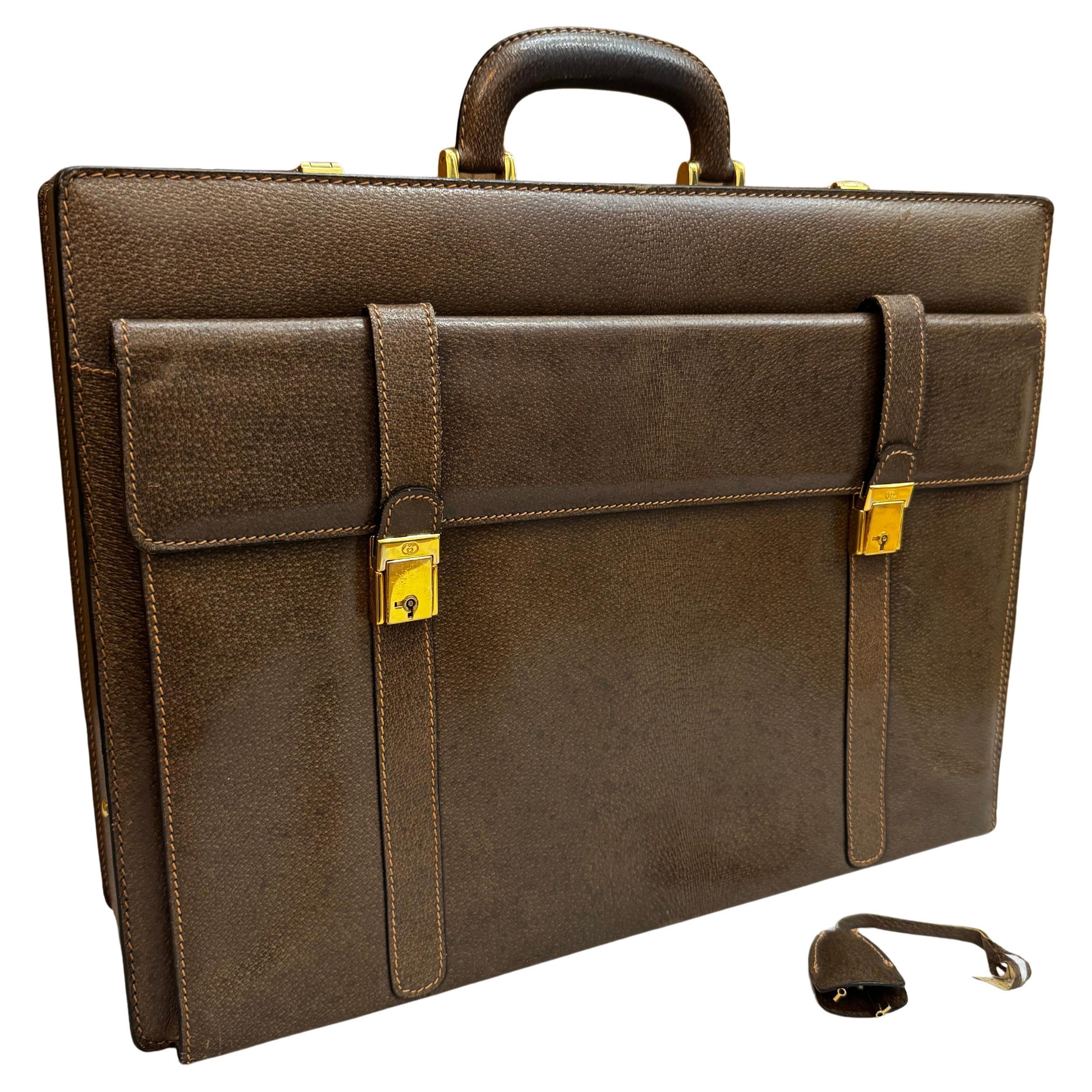 This vintage GUCCI trunk briefcase is crafted of brown pigskin leather featuring gold toned hardware. Top double combination lock closures open to a beige leather interior featuring pockets and holders crafted of the same pigskin leather as the main