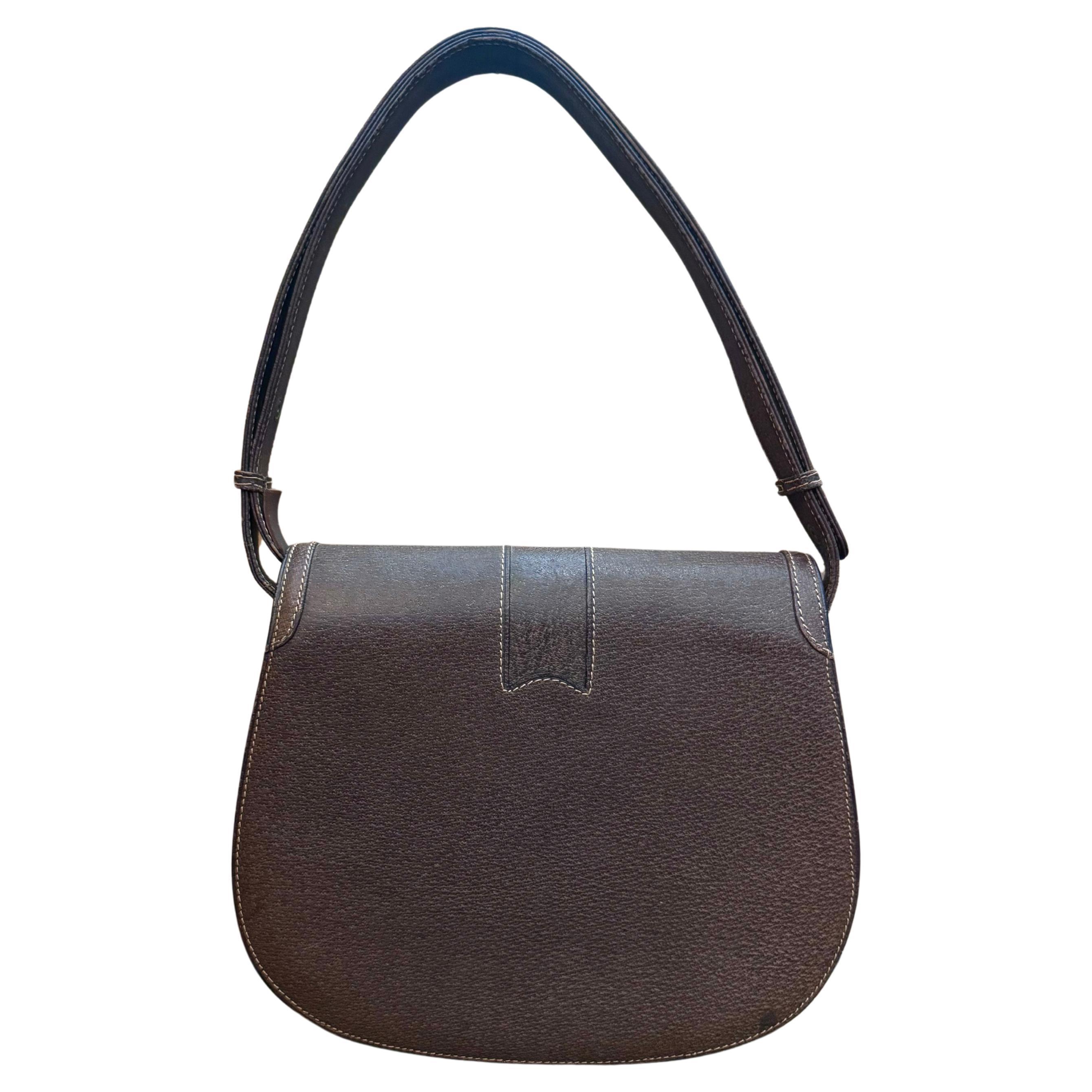 This vintage GUCCI shoulder bag is crafted of pigskin leather in brown featuring gold toned hardware. Front flap buckle closure opens to three compartments in beige leather interior featuring a zippered pocket and a patch pocket. Made in Italy.
