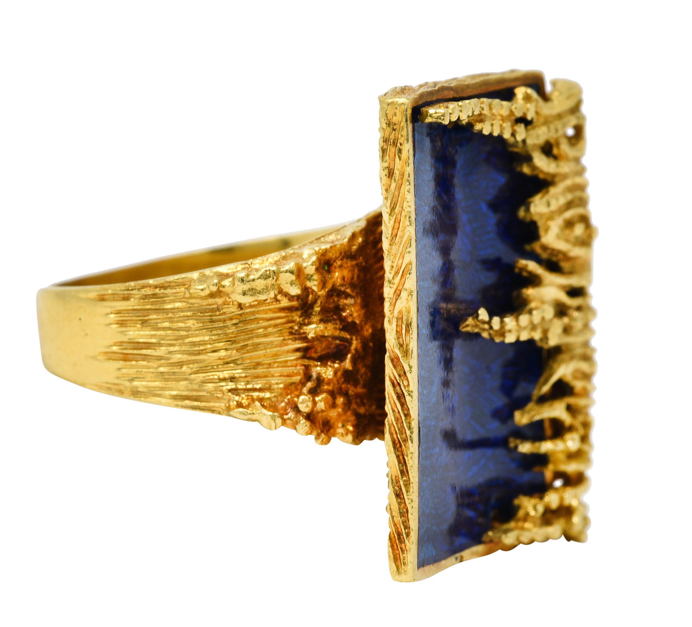Designed as a rectangular form encompassed by texturous vine-like gold

Glossed with guilloche enamel - ombre teal to royal blue with a deeply grooved motif

Completed by a wide and deeply grooved shank with a waved form serving as a connection
