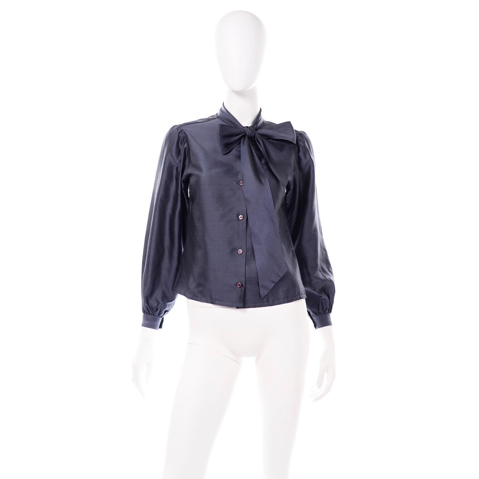 This vintage late 1970's Halston blouse is in a gorgeous blue polished cotton fabric. We love the tie that is attached to the collar that can be worn simply knotted or in a bow . The sleeves are balloon style with gathered fabric at the cuffs and