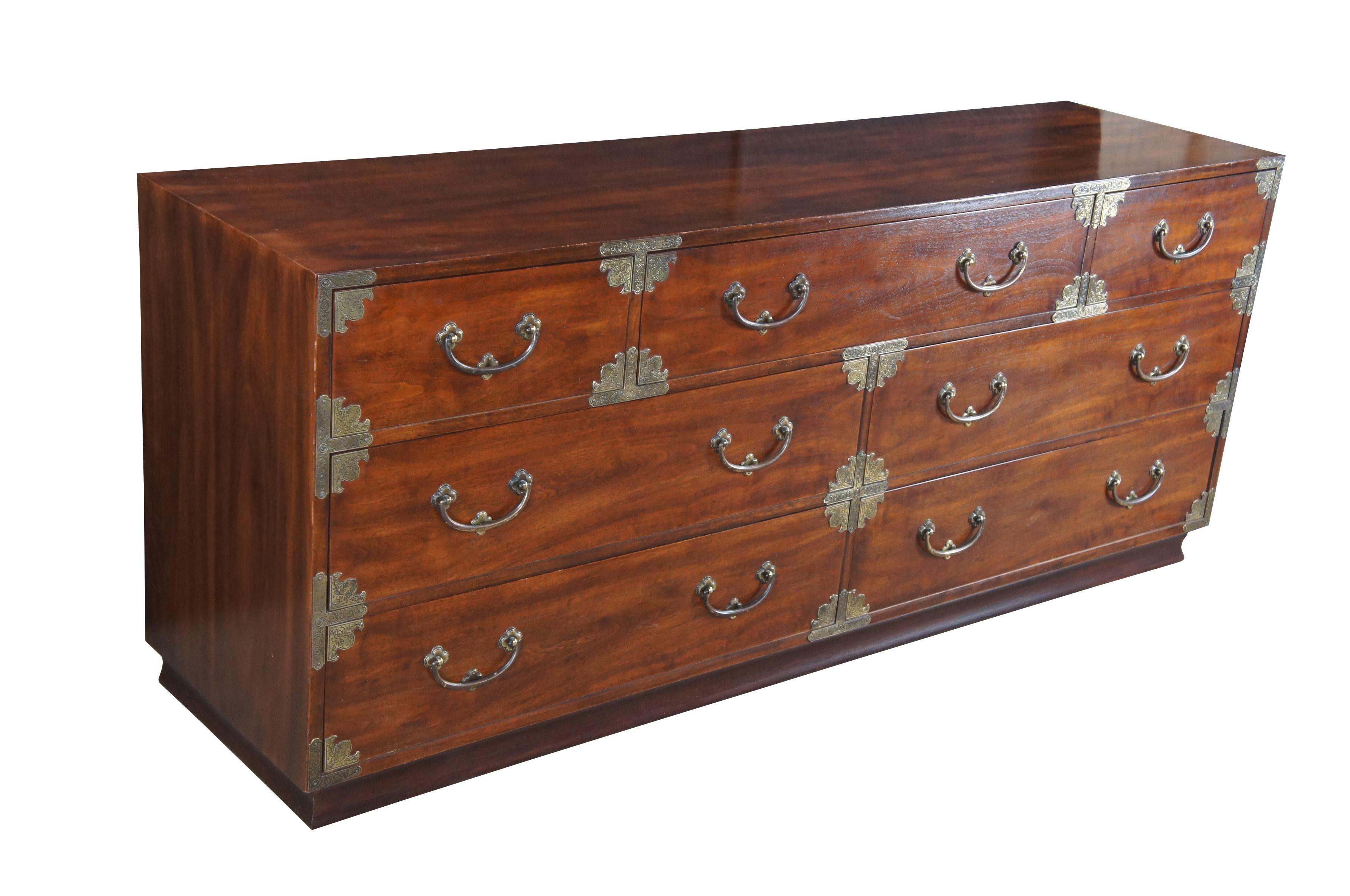 A vintage Henredon lowboy dresser in the Japanese Tansu Campaign style circa 1979.  Part of their far east collection. Features a rectangular frame made from Mahogany with seven dovetailed drawers, brass pulls and embossed brass chinoiserie accents.