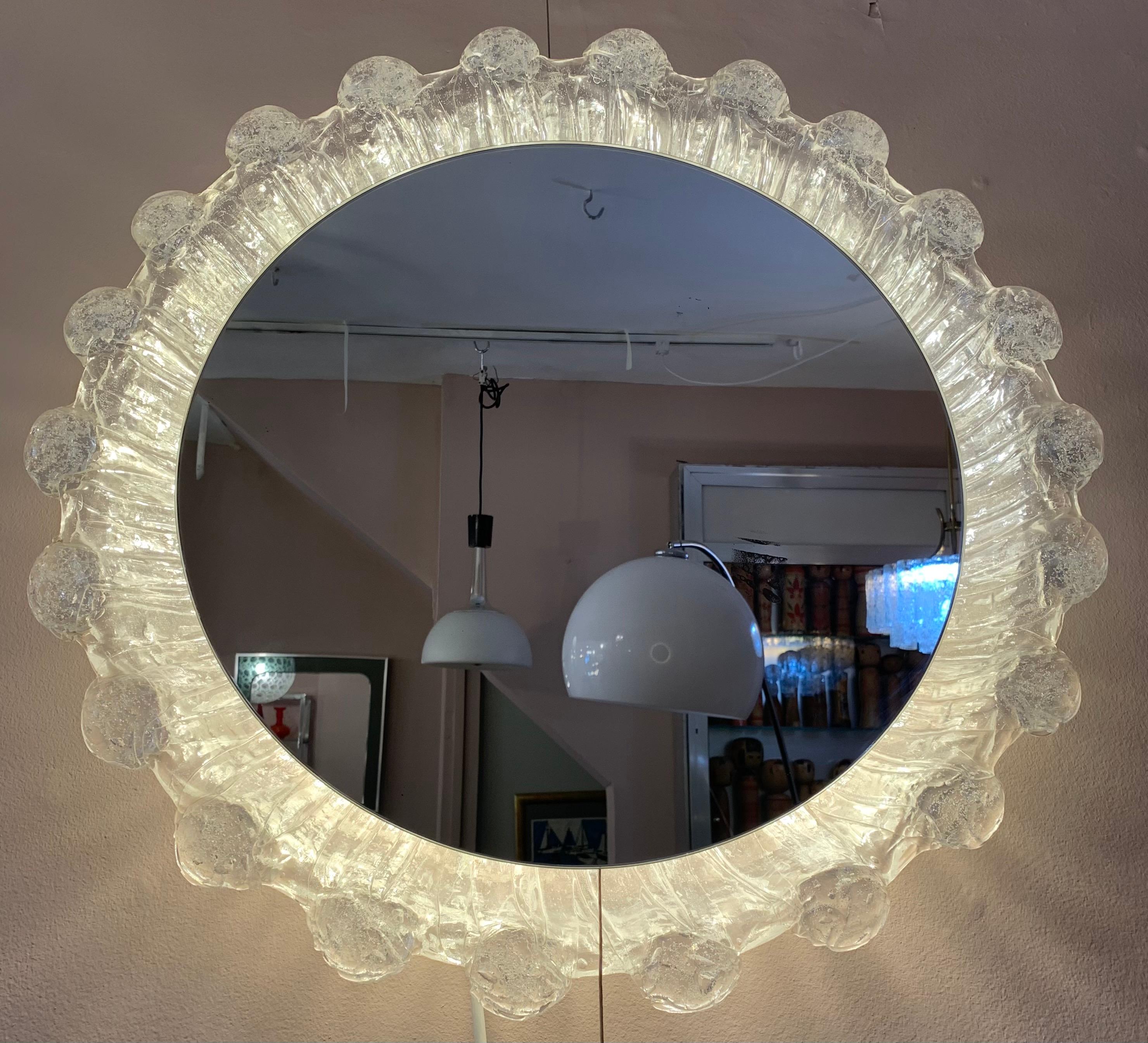 Vintage 1970s German, illuminated, back-lit, wall mirror formed from a lucite glass mottled frame in the shape of a water droplet. Manufactured by Miradur-Werk, Dusseldorf. The manufacturers label is still visible on the frame. The round mirror