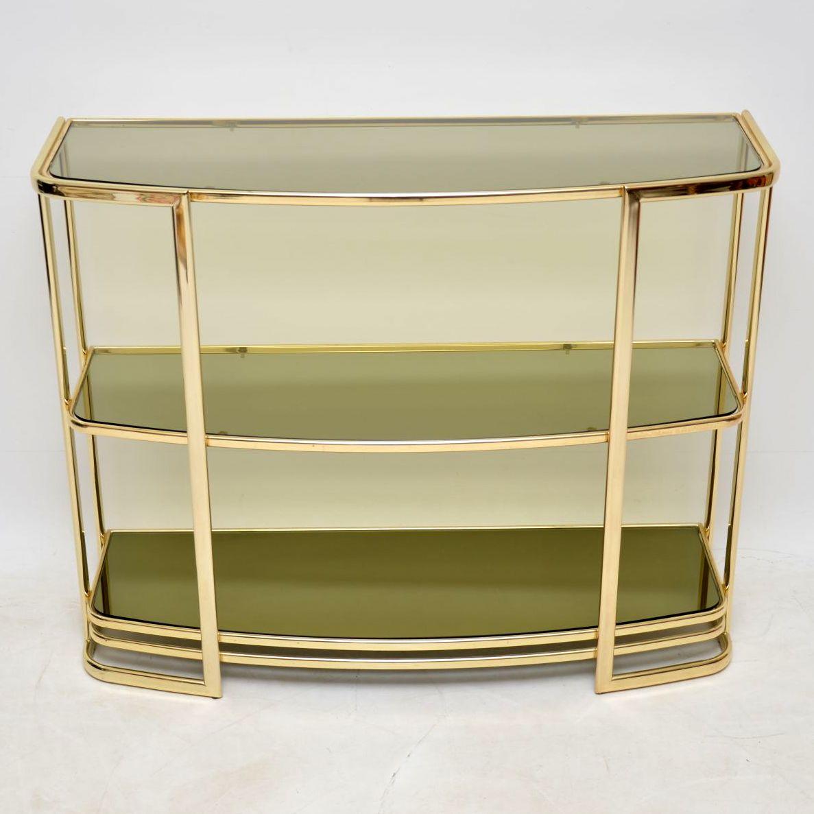 A beautiful and very well made vintage brass wall unit, this was made in Italy and it dates from around the 1970s. It’s in great condition for its age, with only some extremely minor wear here and there. It has two smoked glass upper shelves, and