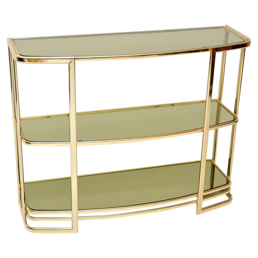 A beautiful and very well made vintage brass wall unit, this was made in Italy and it dates from circa 1970s. It’s in great condition for its age, with only some extremely minor wear here and there. It has two smoked glass upper shelves, and the